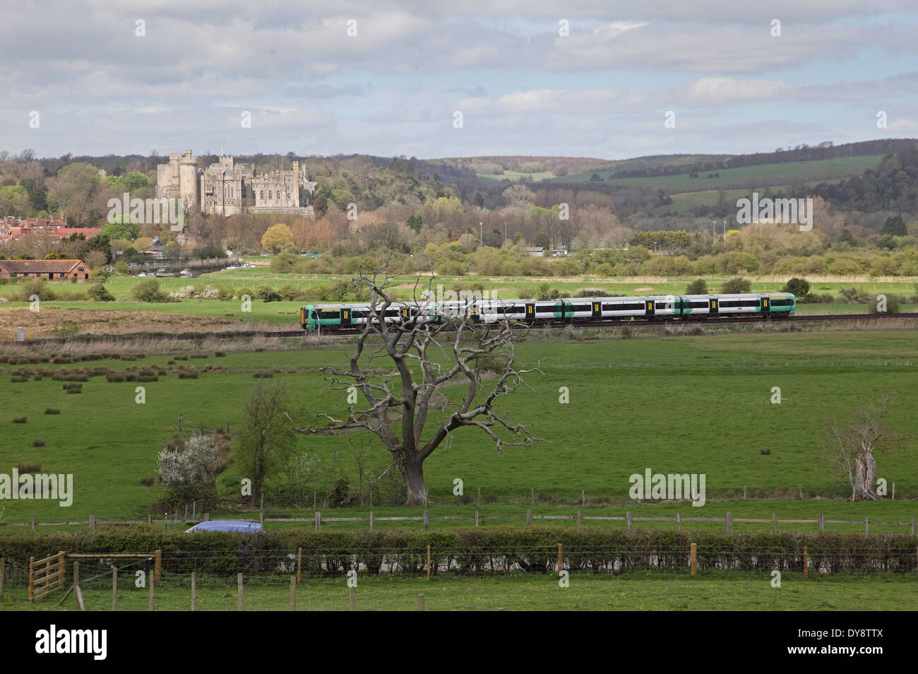 Un train du Sud passe devant le château historique d'Arundal, West Sussex, Royaume-Uni. Le parc national de South Downs en arrière-plan Banque D'Images