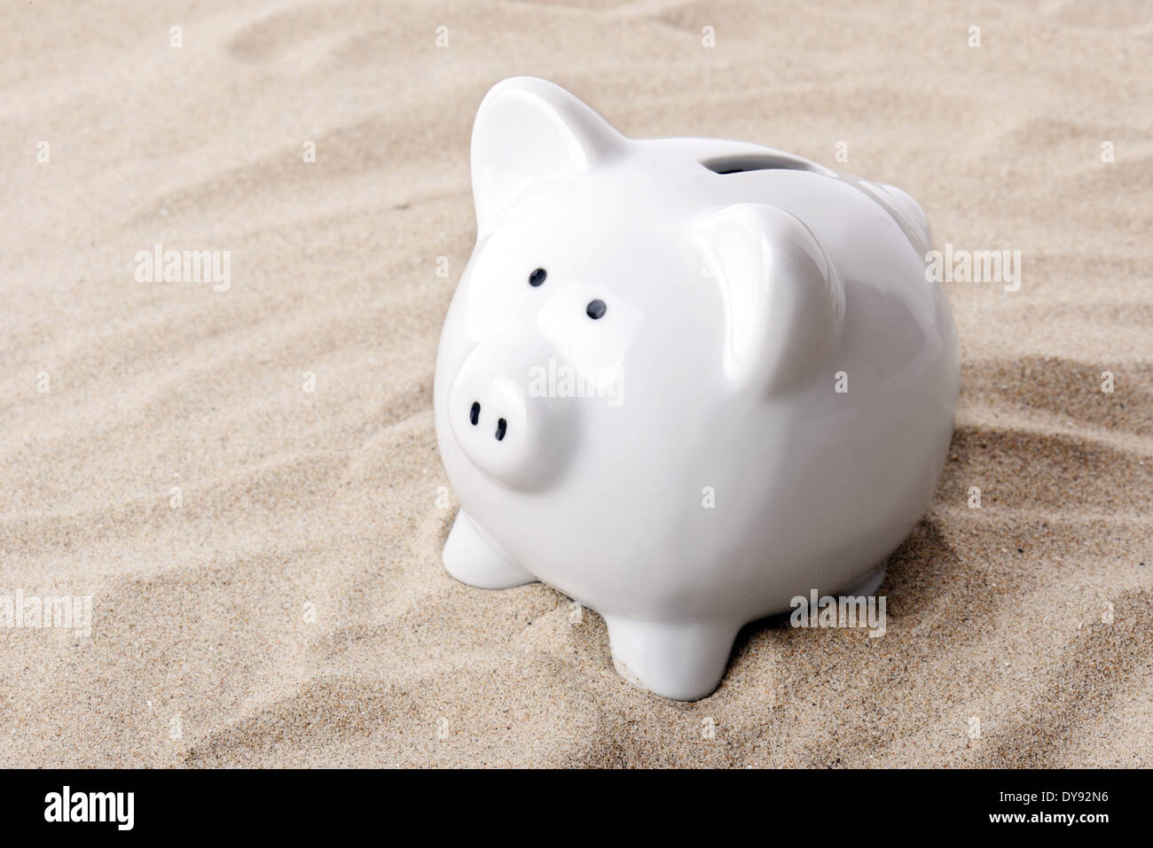 Piggy Bank dans le sable qui permet d'économiser jusqu'locations Banque D'Images