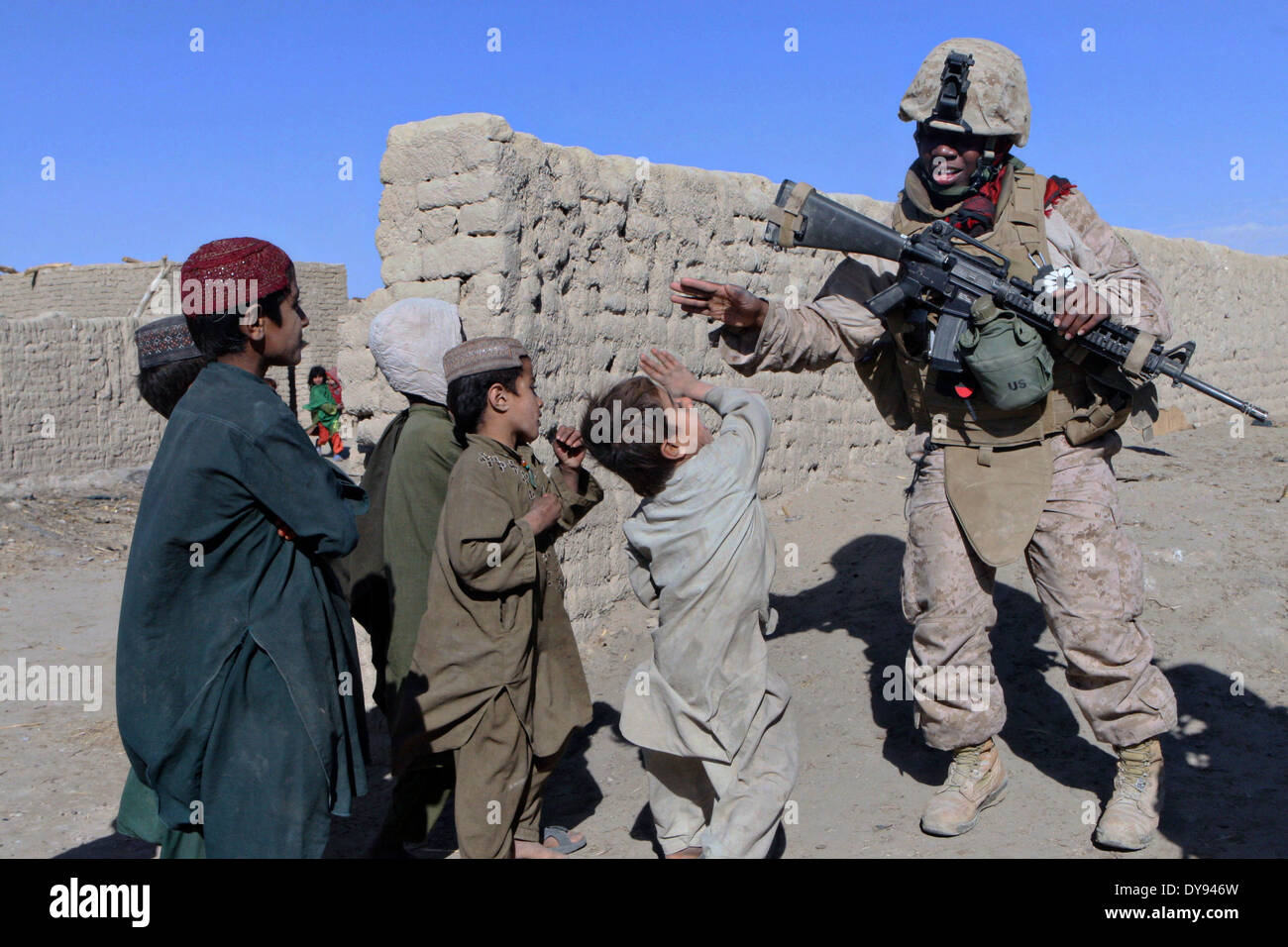 US Marine Corps Lance Cpl. Autayvia K. Mitchell avec une équipe de l'engagement des femmes joue des enfants afghans lors d'une patrouille dans le village de Khar tadjike, 18 décembre 2009 dans le district de Garmsir, province de Helmand, en Afghanistan. Banque D'Images