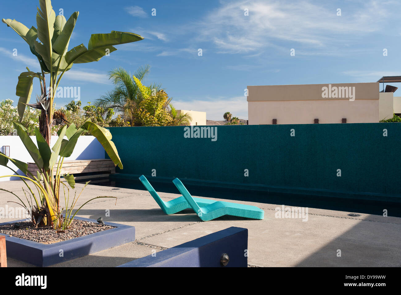 Chaises longues contemporain dans une cour de l'hôtel avec piscine Banque D'Images