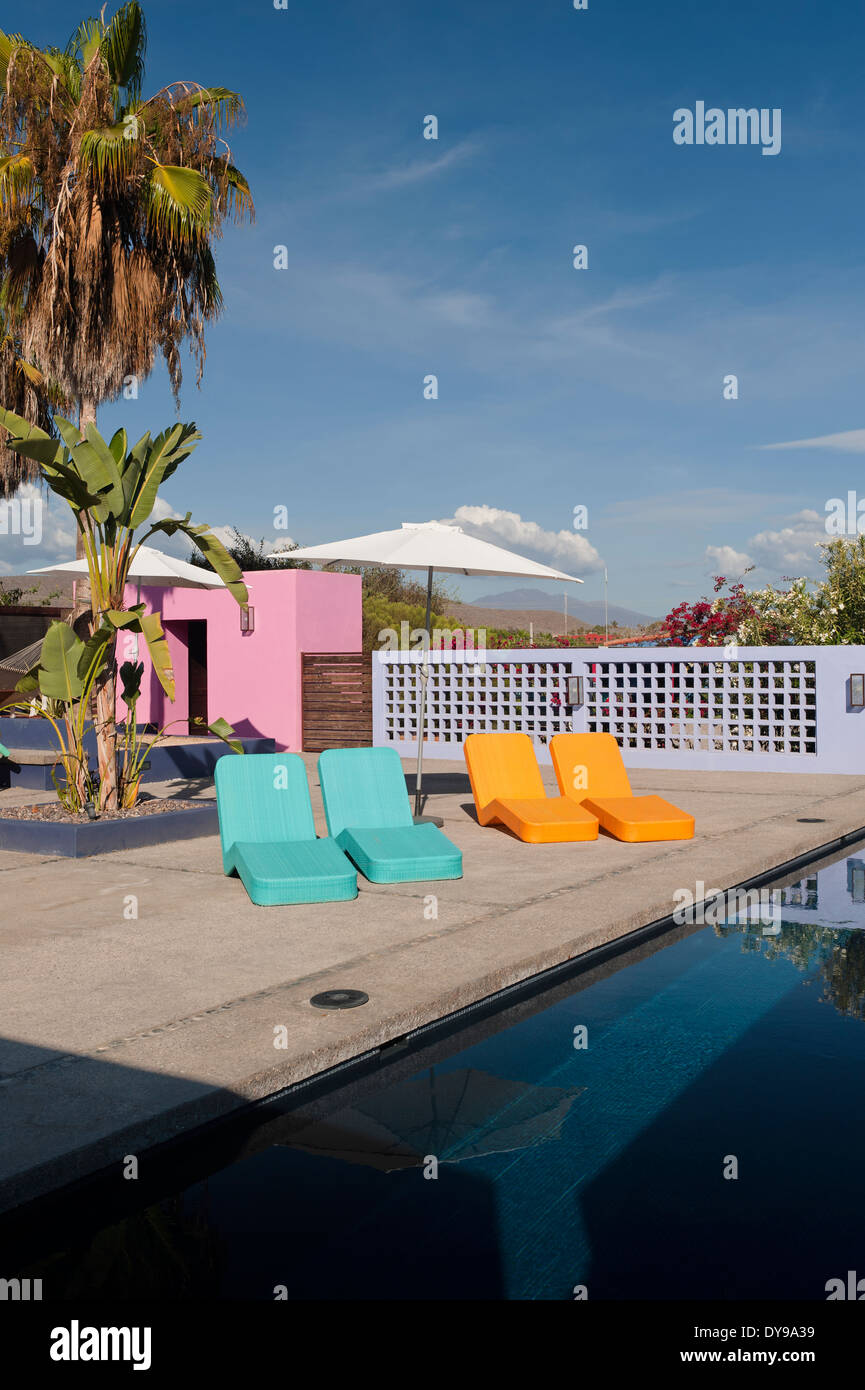 Chaises longues contemporain dans une cour de l'hôtel avec piscine et dépendance rose Banque D'Images