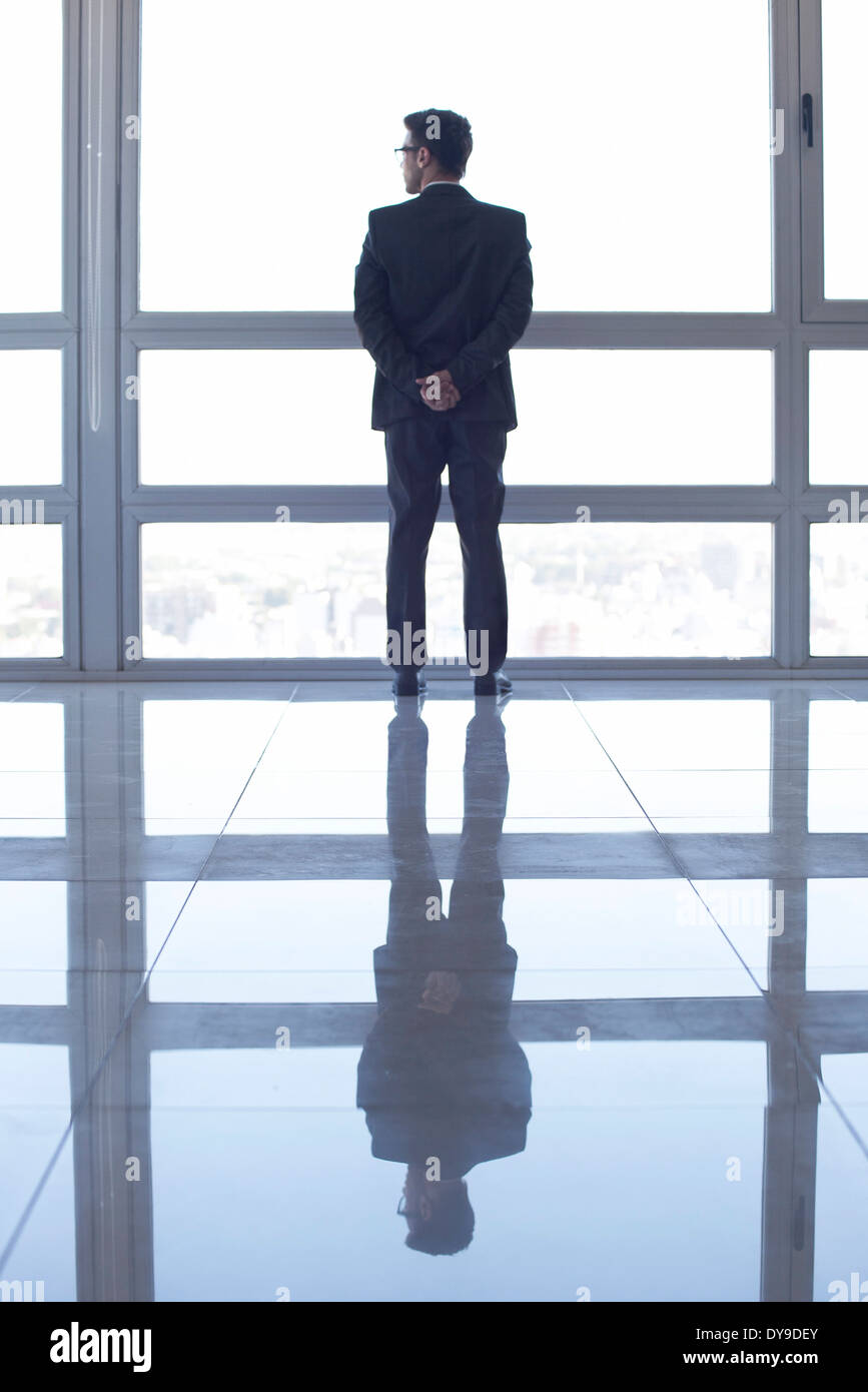 Homme debout en face de la fenêtre, looking at view Banque D'Images