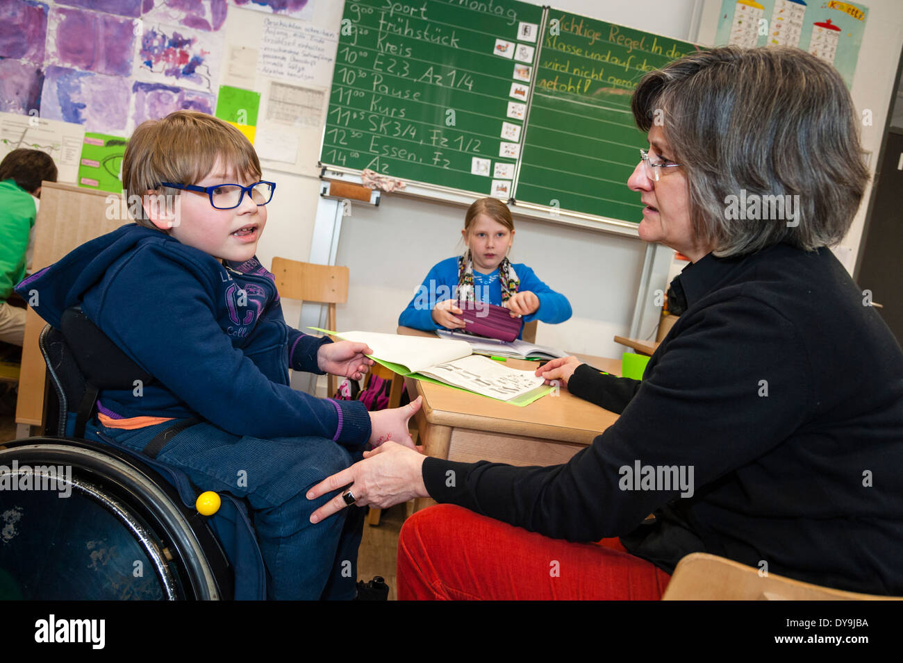La non-mobilité et de mobilité des étudiants (dans ce cas un petit garçon dans un fauteuil roulant) apprendre ensemble dans la même classe dans une école primaire. Banque D'Images