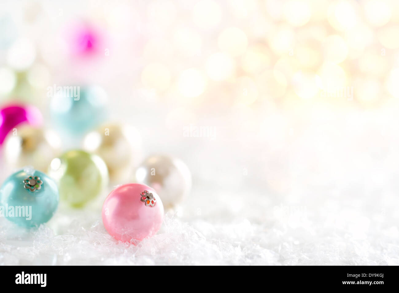 Boule de Noël couleur pastel lumineux décor sur fond flou et la neige Banque D'Images