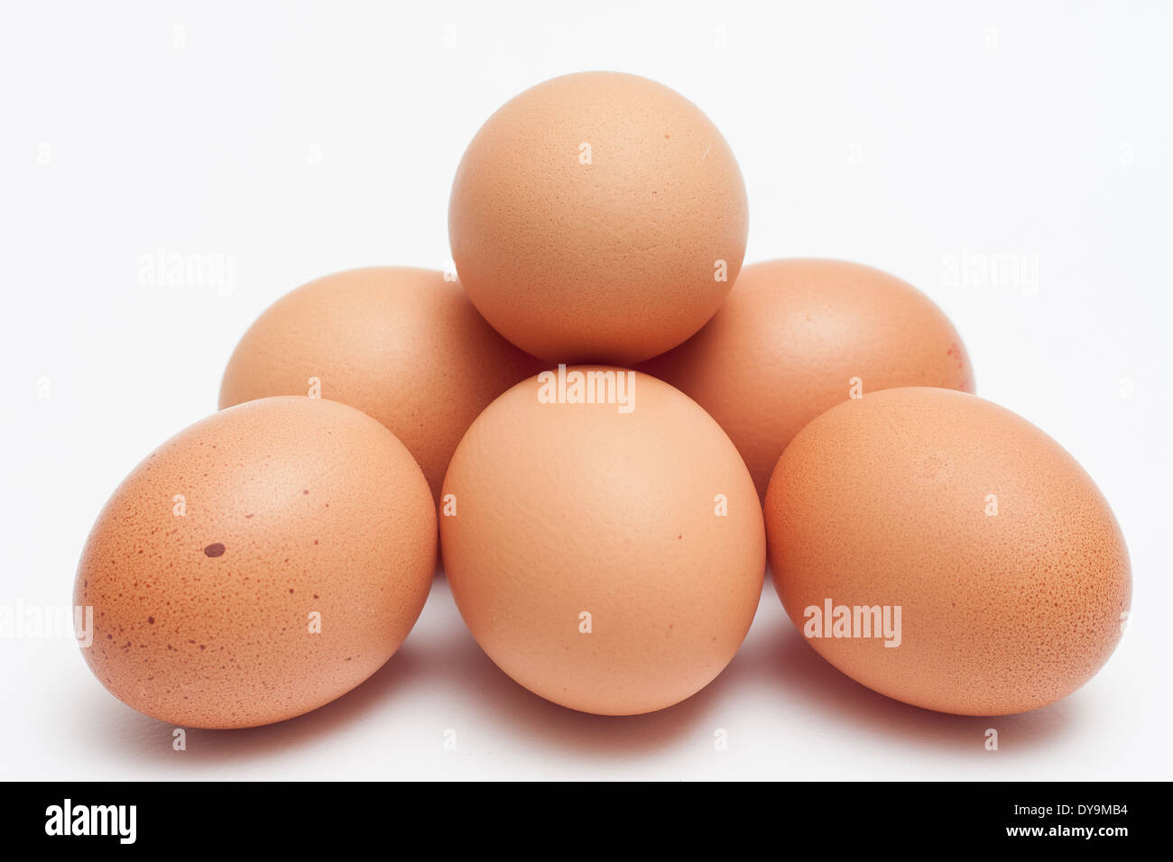 Oeuf de poule en forme de pyramide, pieu isolé sur fond blanc Banque D'Images