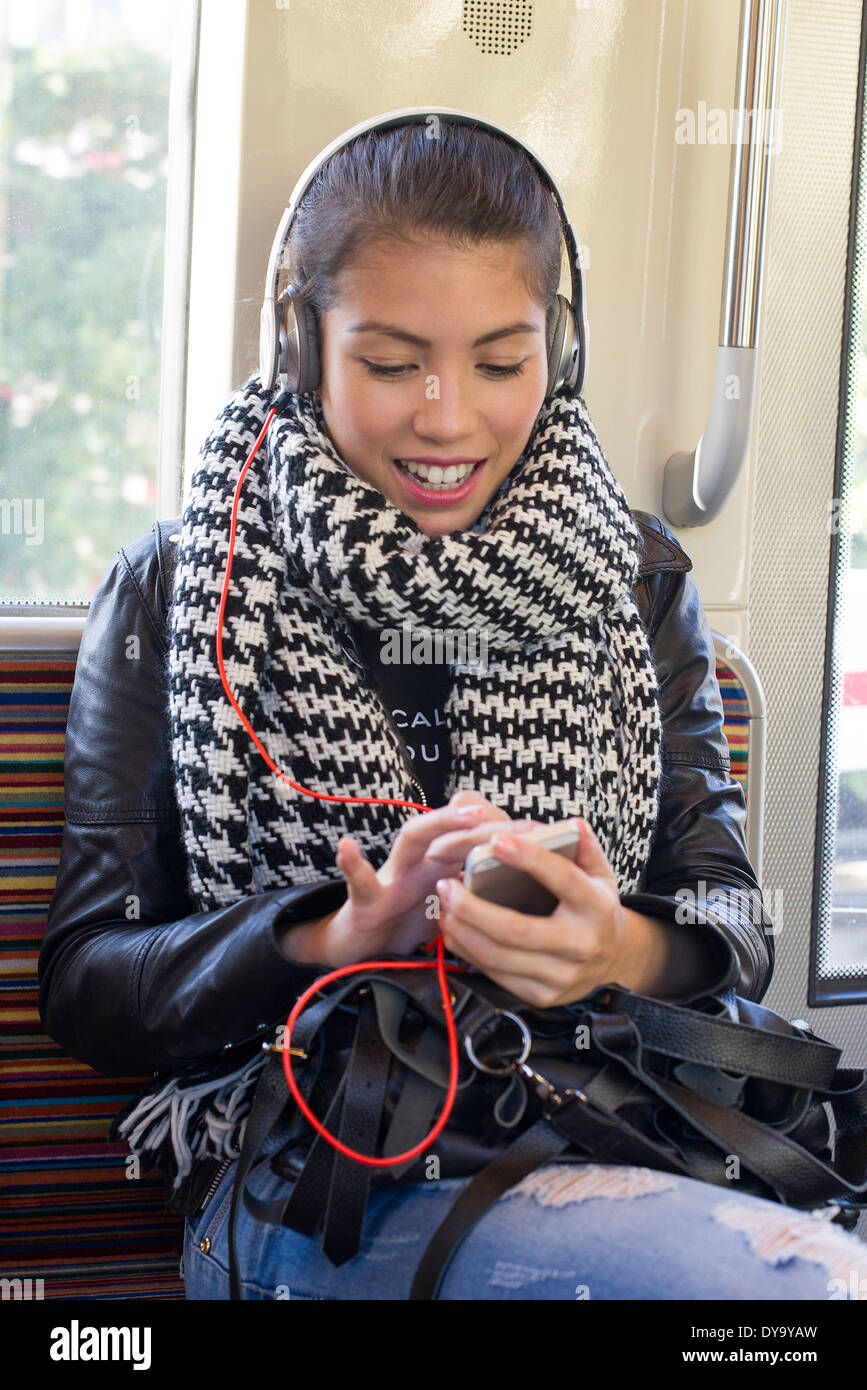 Young woman using smartphone on Subway train Banque D'Images