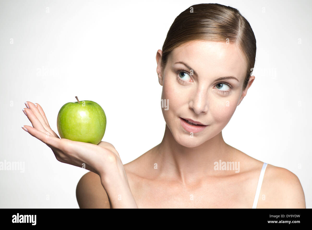 Young woman holding up green apple Banque D'Images