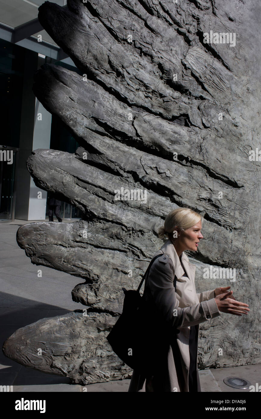 Une dame gesticule avec ses doigts, faisant écho aux ailes à plumes d'une ailes de l'œuvre en bronze de la ville de Londres. Les dix mètres de haut est la sculpture en bronze par le président de la Royal Academy of Arts, Christopher Le Brun, commandé par Hammerson en 2009. Elle est appelée 'La Ville' de l'aile et a été jeté par Morris Singer, fondateurs de l'art réputé pour être la plus ancienne fonderie d'art dans le monde. Banque D'Images