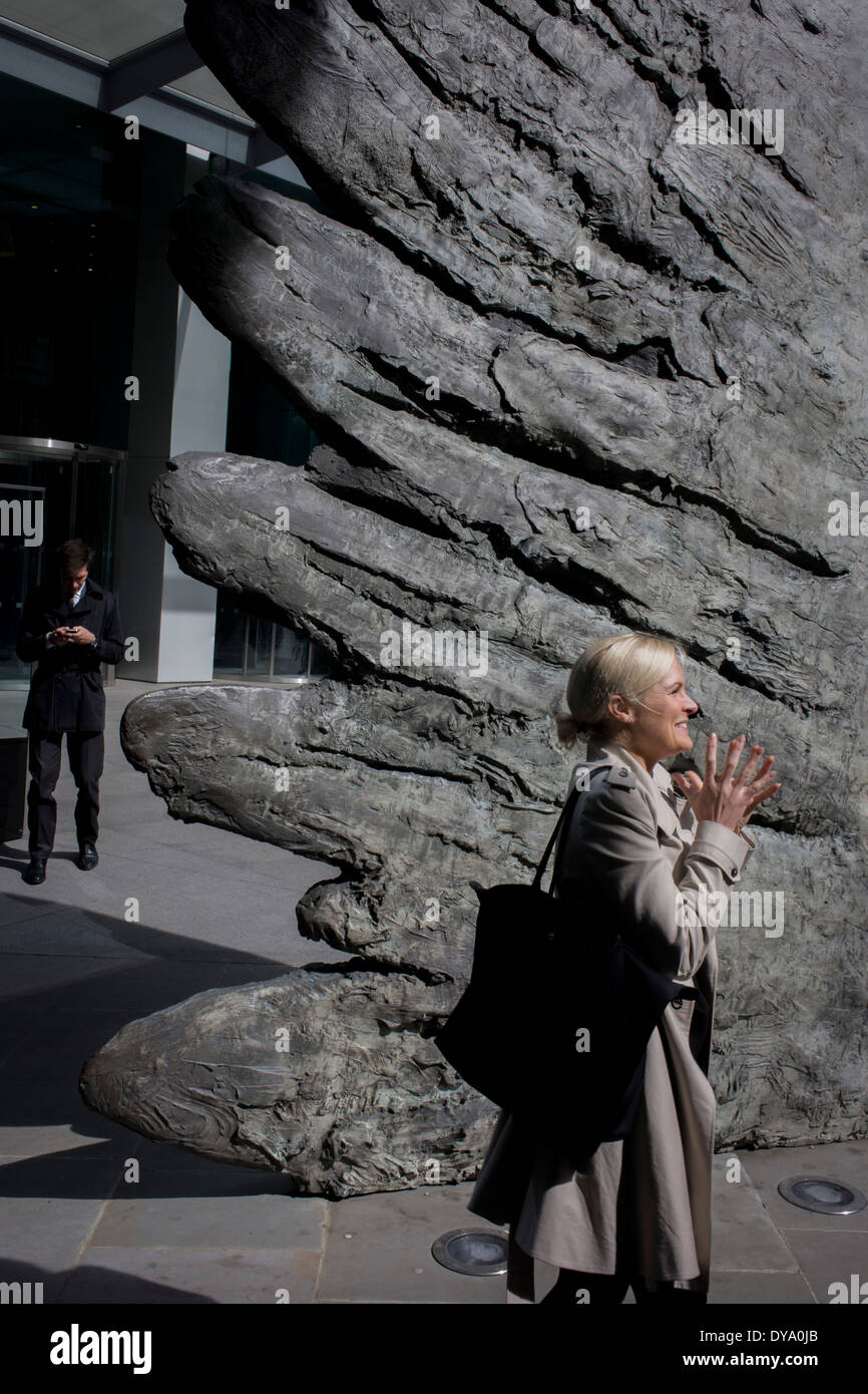 Une dame gesticule avec ses doigts, faisant écho aux ailes à plumes d'une ailes de l'œuvre en bronze de la ville de Londres. Les dix mètres de haut est la sculpture en bronze par le président de la Royal Academy of Arts, Christopher Le Brun, commandé par Hammerson en 2009. Elle est appelée 'La Ville' de l'aile et a été jeté par Morris Singer, fondateurs de l'art réputé pour être la plus ancienne fonderie d'art dans le monde. Banque D'Images