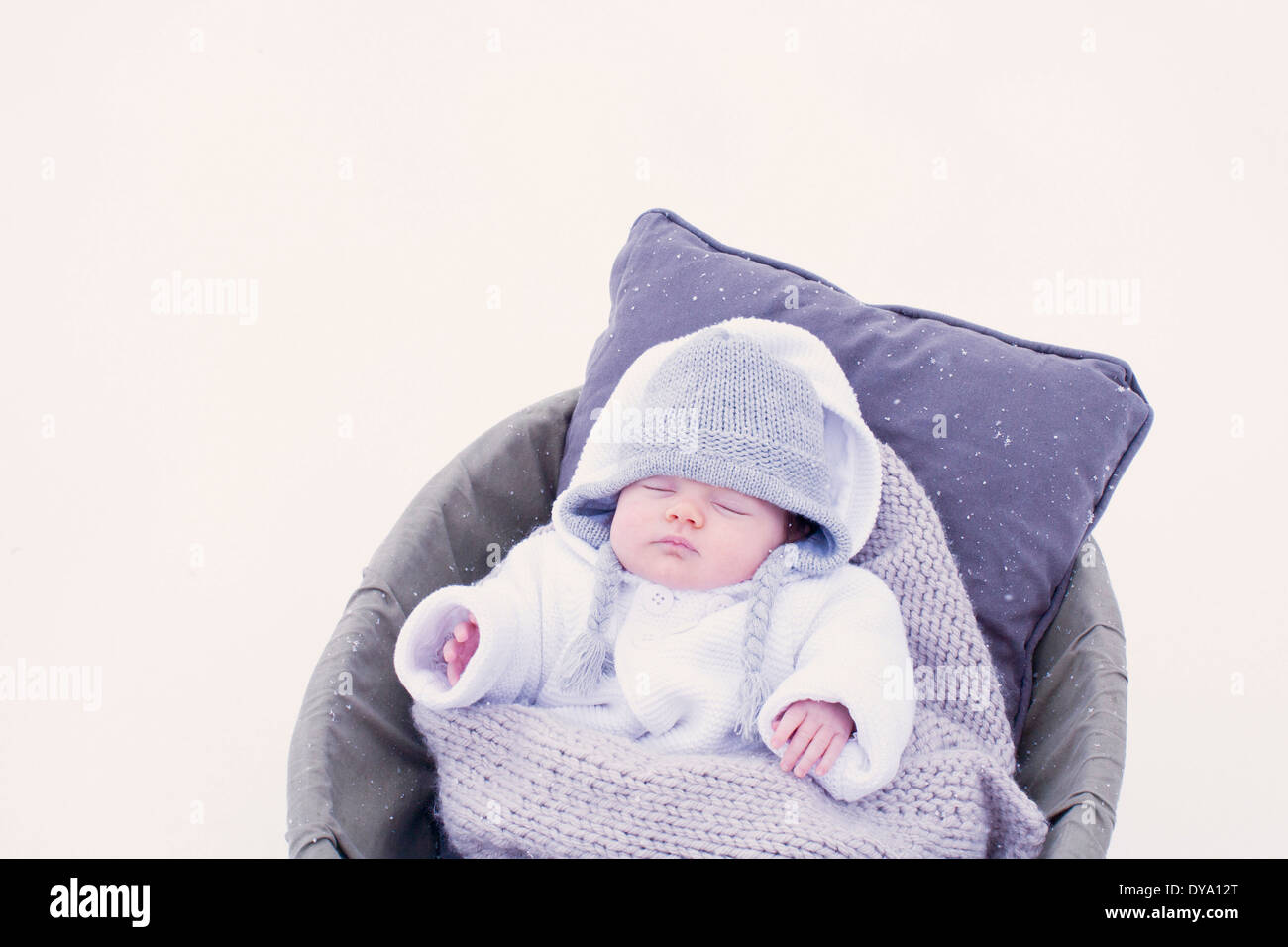 Baby sleeping in bassinet in snow Banque D'Images