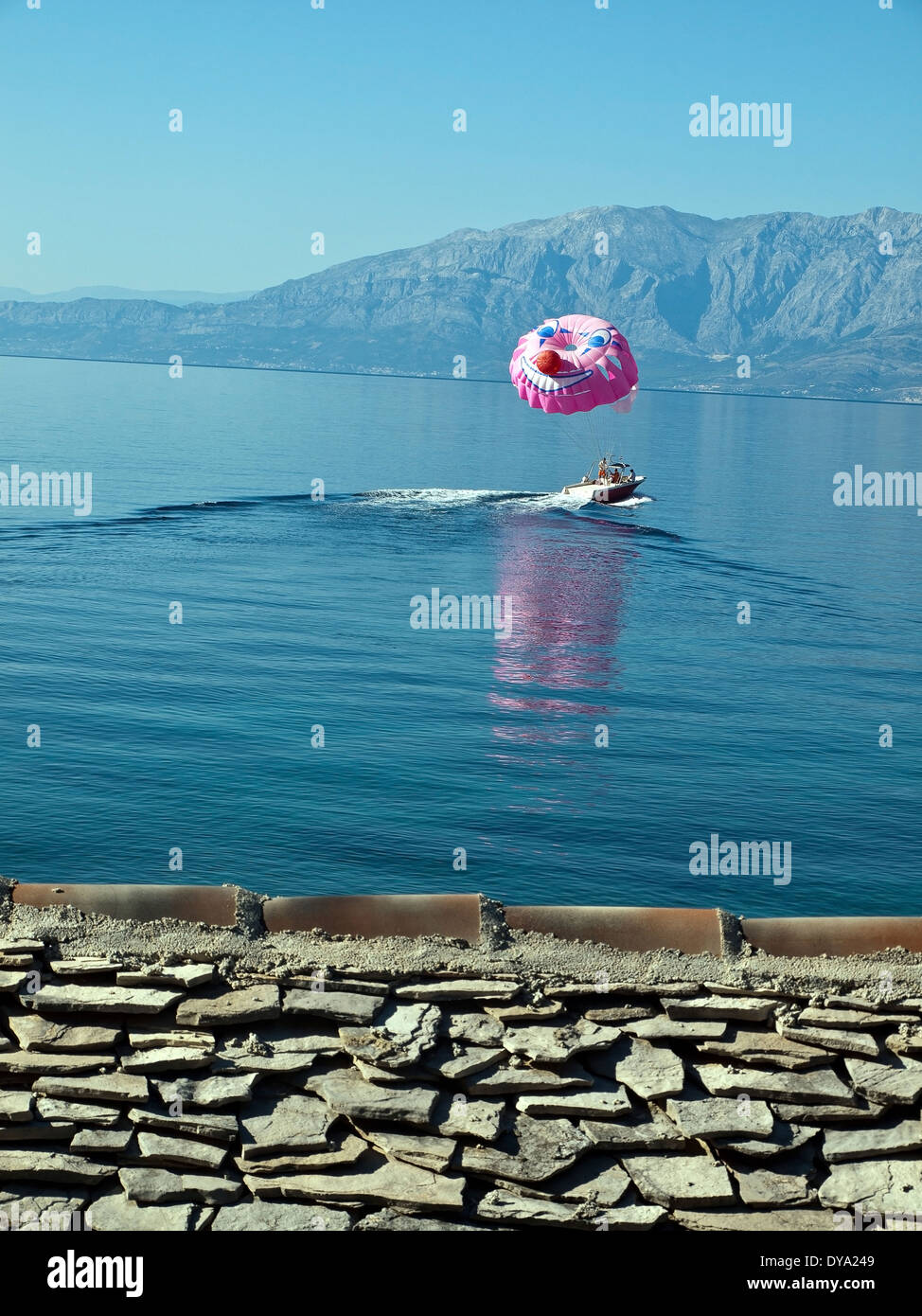Bateau avec parachute sur la mer bleu calme Banque D'Images