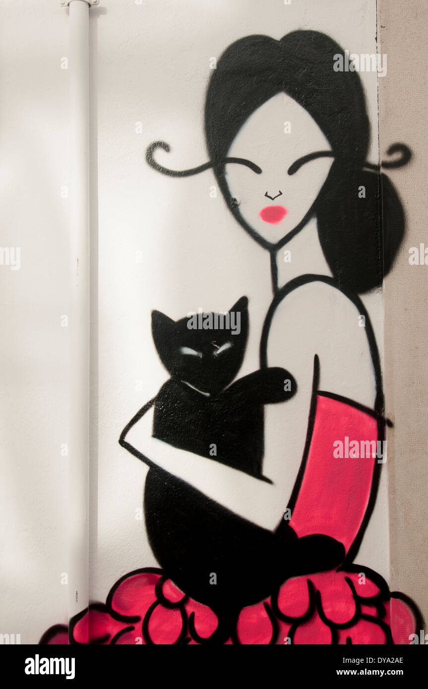 L'art de rue, graffiti sur un mur à Lagos au Portugal. Dame tenant un chat noir Banque D'Images
