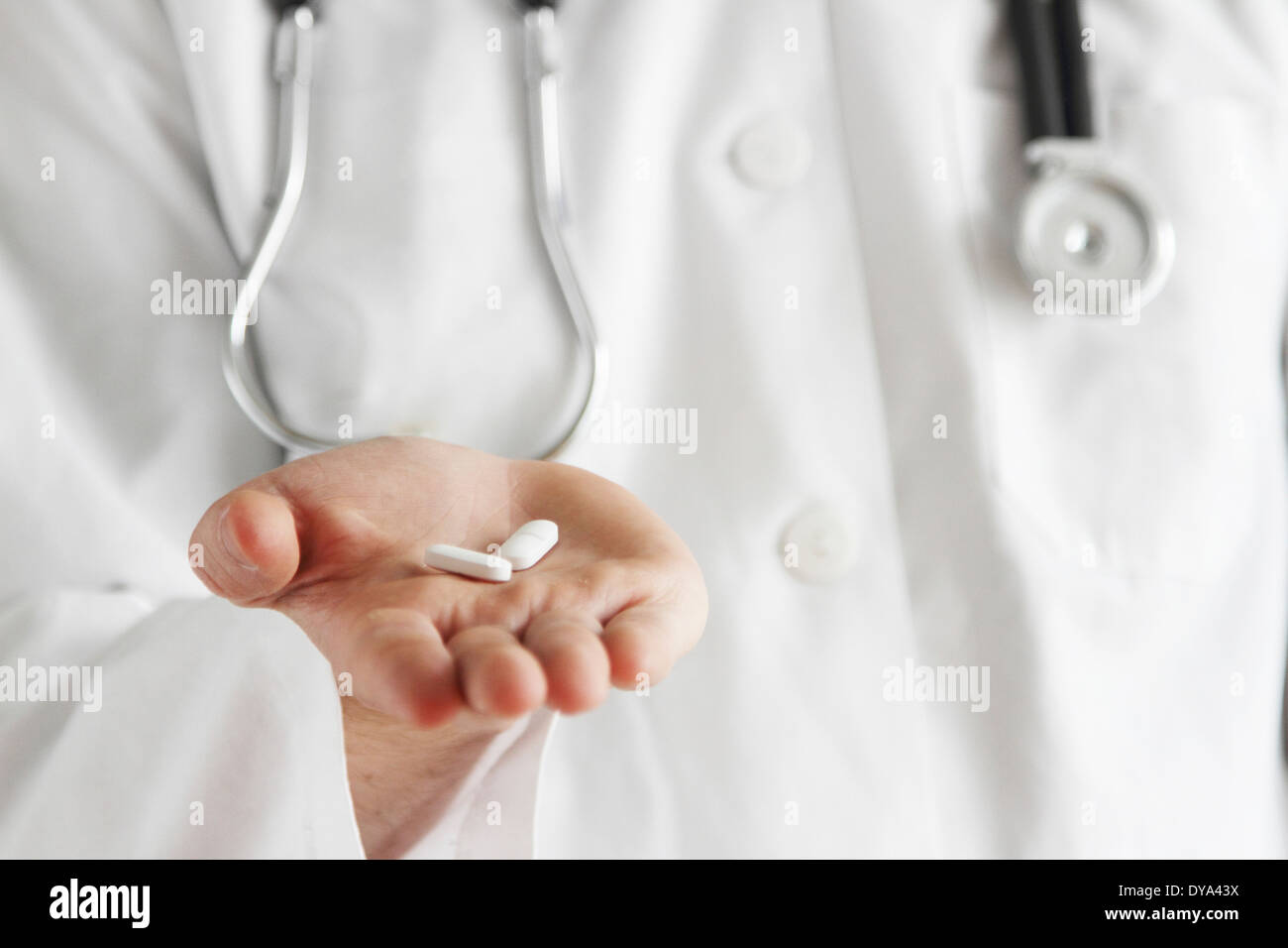 Jeune médecin avec blouse blanche et stéthoscope avec pills Banque D'Images