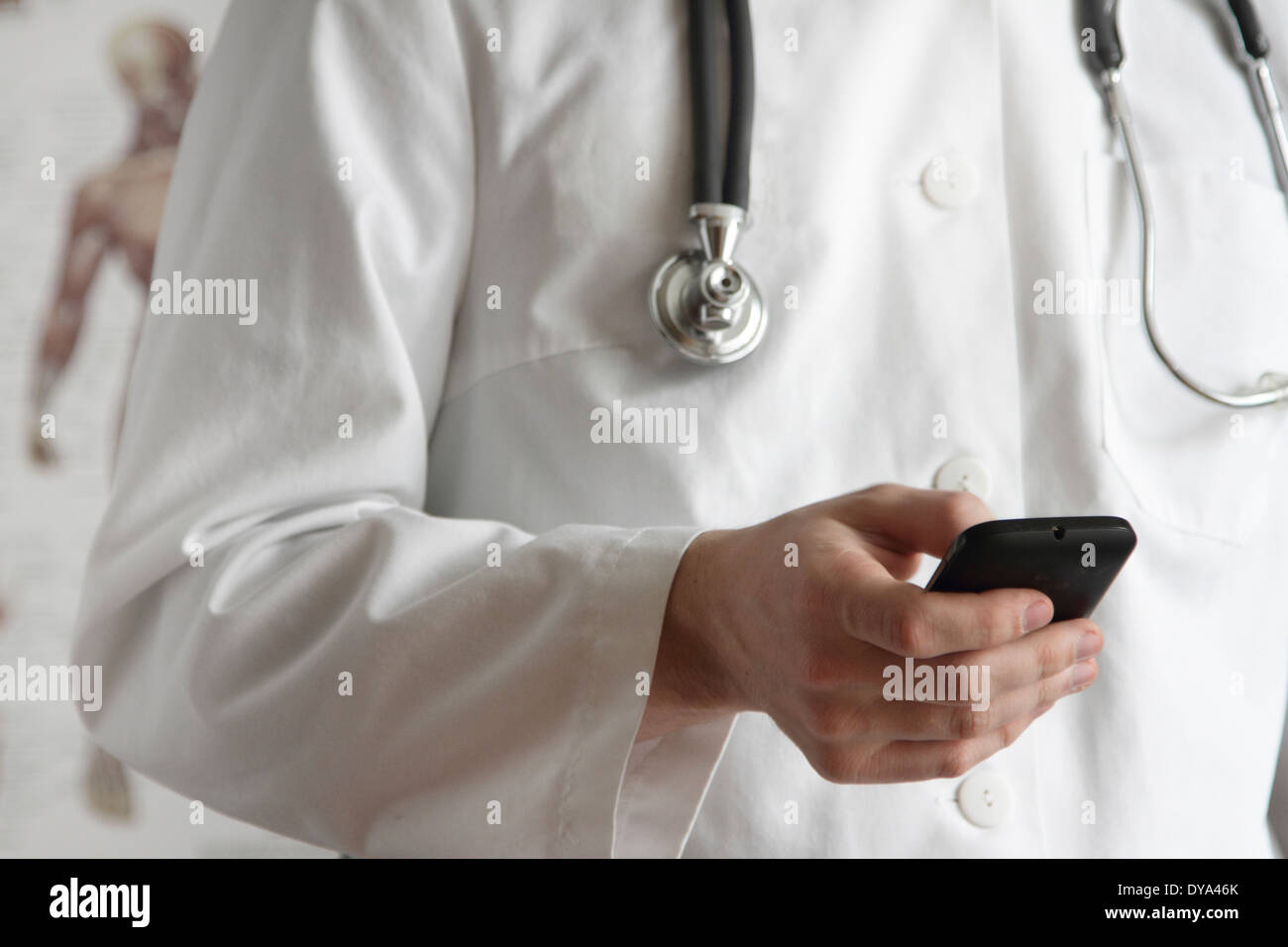 Jeune médecin avec blouse blanche et stéthoscope avec un téléphone mobile Banque D'Images