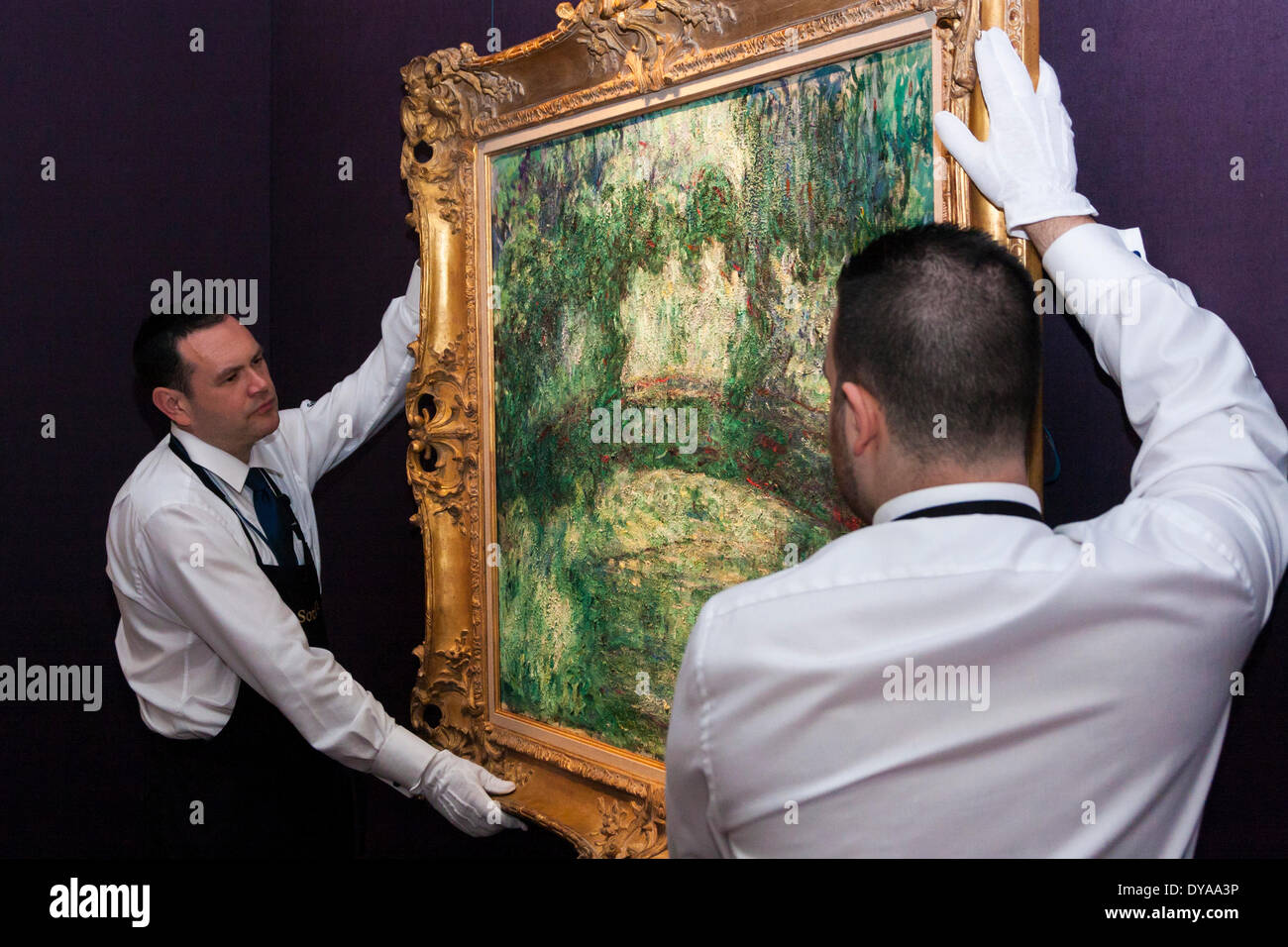 Londres, le 11 avril 2014. Sotheby's personnel régler la pendaison de Claude Monet Le pont japonais, sur l'aperçu à Londres avant d'être mis aux enchères dans votre nouvelle le 7 mai où la peinture est estimée à jusqu'à 18 millions de dollars. Crédit : Paul Davey/Alamy Live News Banque D'Images