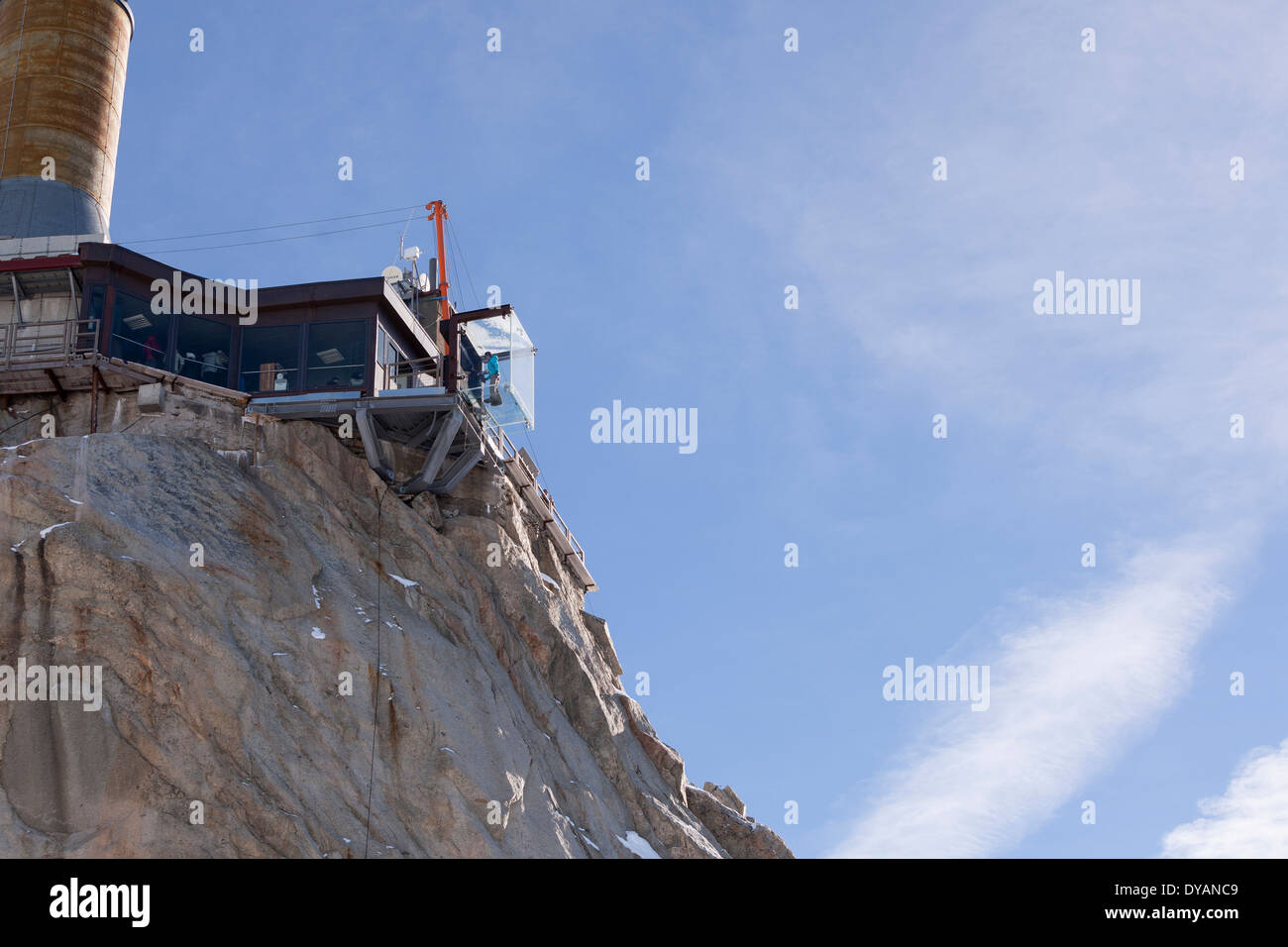 Un touriste se trouve dans le 'Step dans le Vide' boîte de verre sur l'Aiguille du Midi (3842 m) sommet de montagne au-dessus de Chamonix Mont-Blanc Banque D'Images