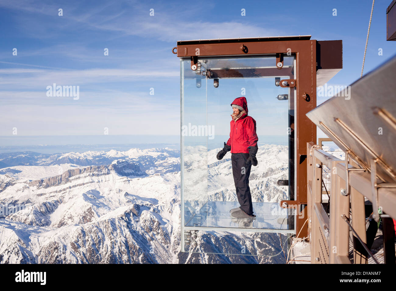 Un touriste se trouve dans le 'Step dans le Vide' boîte de verre sur l'Aiguille du Midi (3842 m) sommet de montagne au-dessus de Chamonix Mont-Blanc Banque D'Images