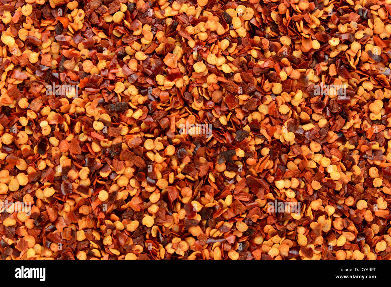 Flocons de piments secs et graines, ou piment rouge broyé, texture de fond abstrait Banque D'Images
