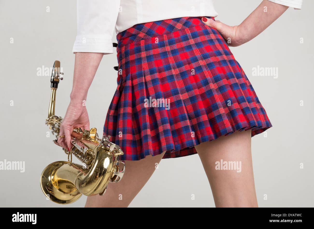 Femme en jupe tartan courts portant un sax Saxophone Banque D'Images