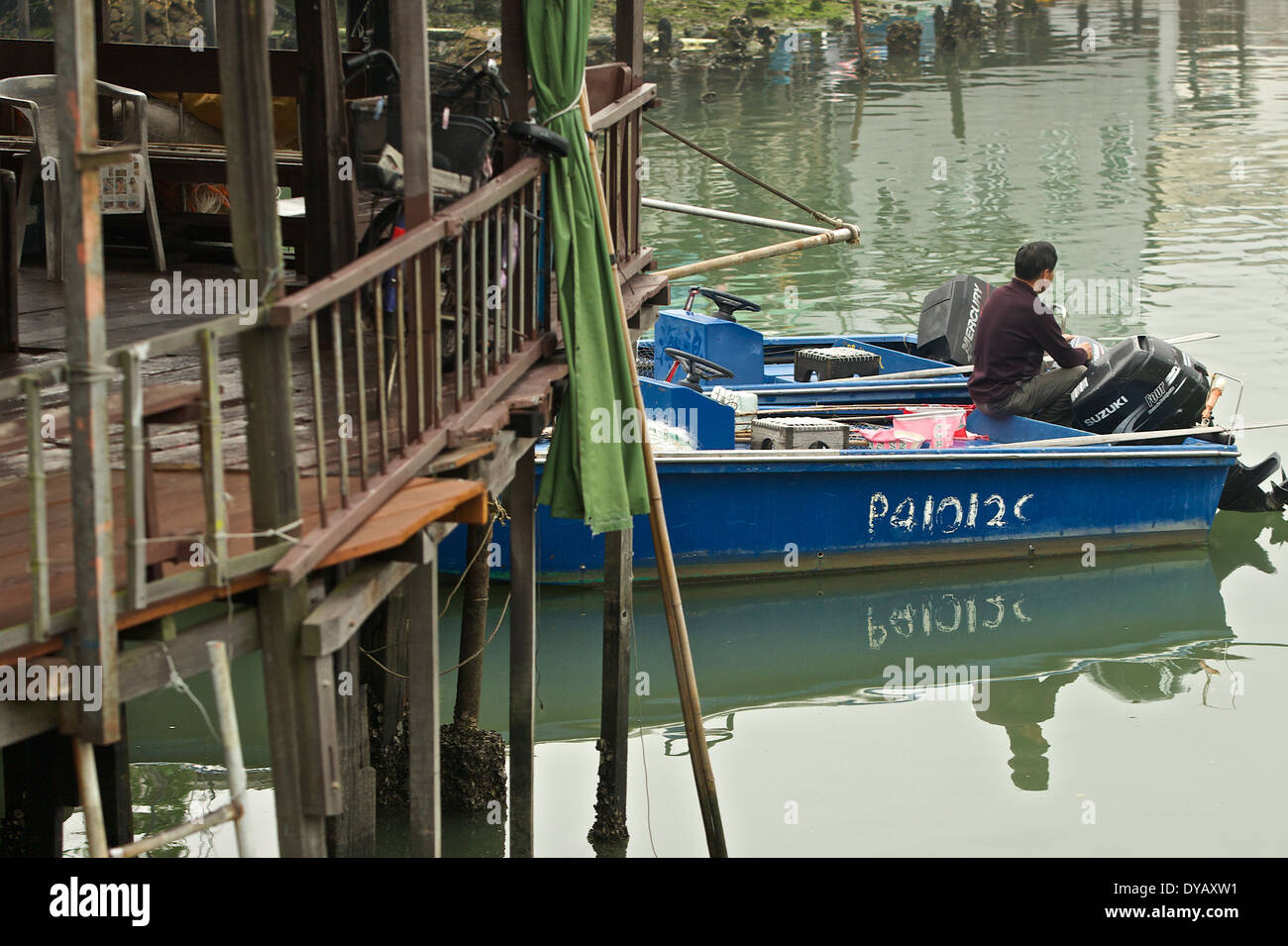 Pêcheur assis dans son bateau de pêche dans le village de pêcheurs Tai O, Lantau Island, Hong Kong. Banque D'Images