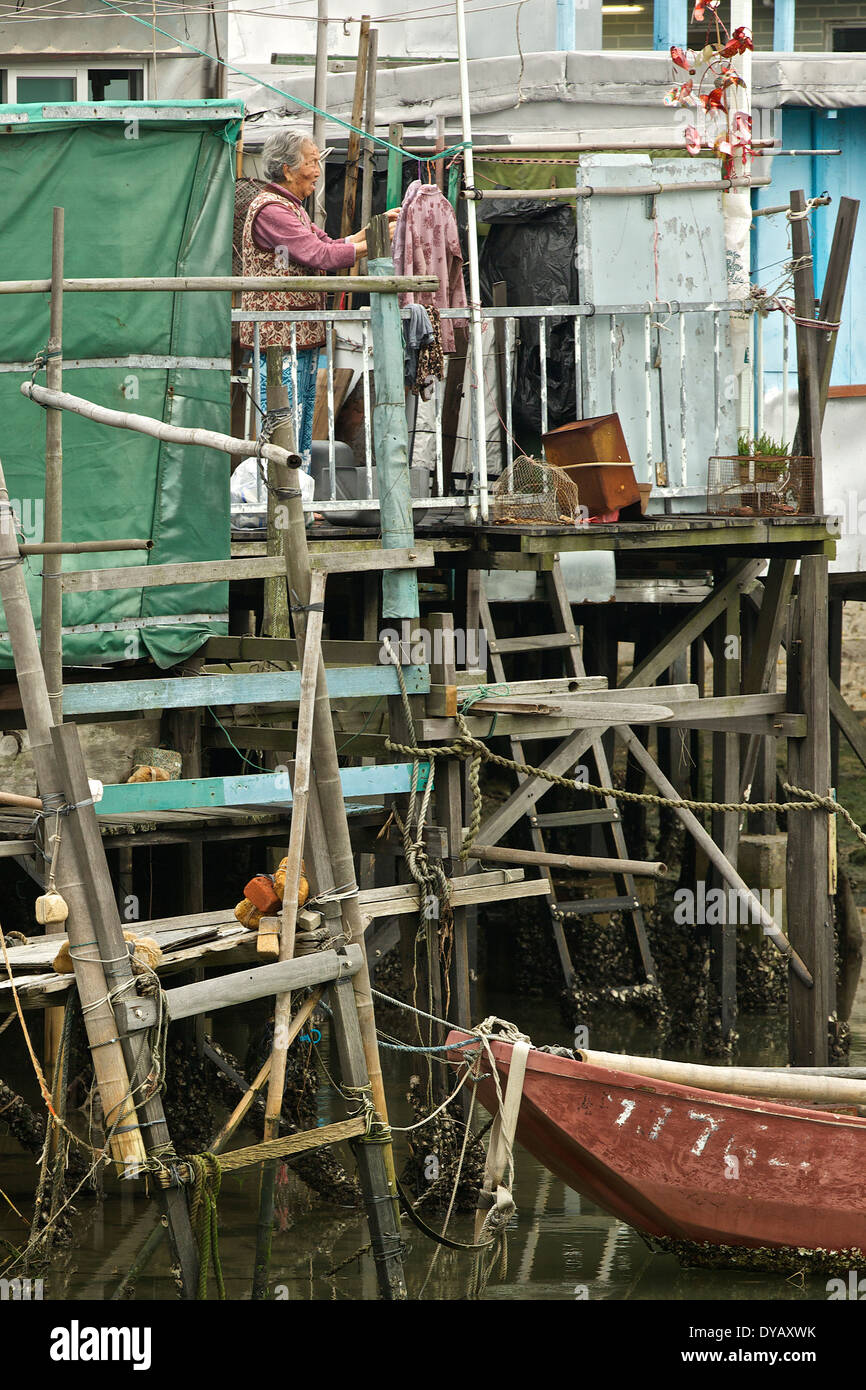 Personnes âgées femme chinoise à l'extérieur de sa maison sur pilotis dans 'Tai O' Chinois traditionnel village de pêcheurs sur l'île de Lantau, à Hong Kong. Banque D'Images
