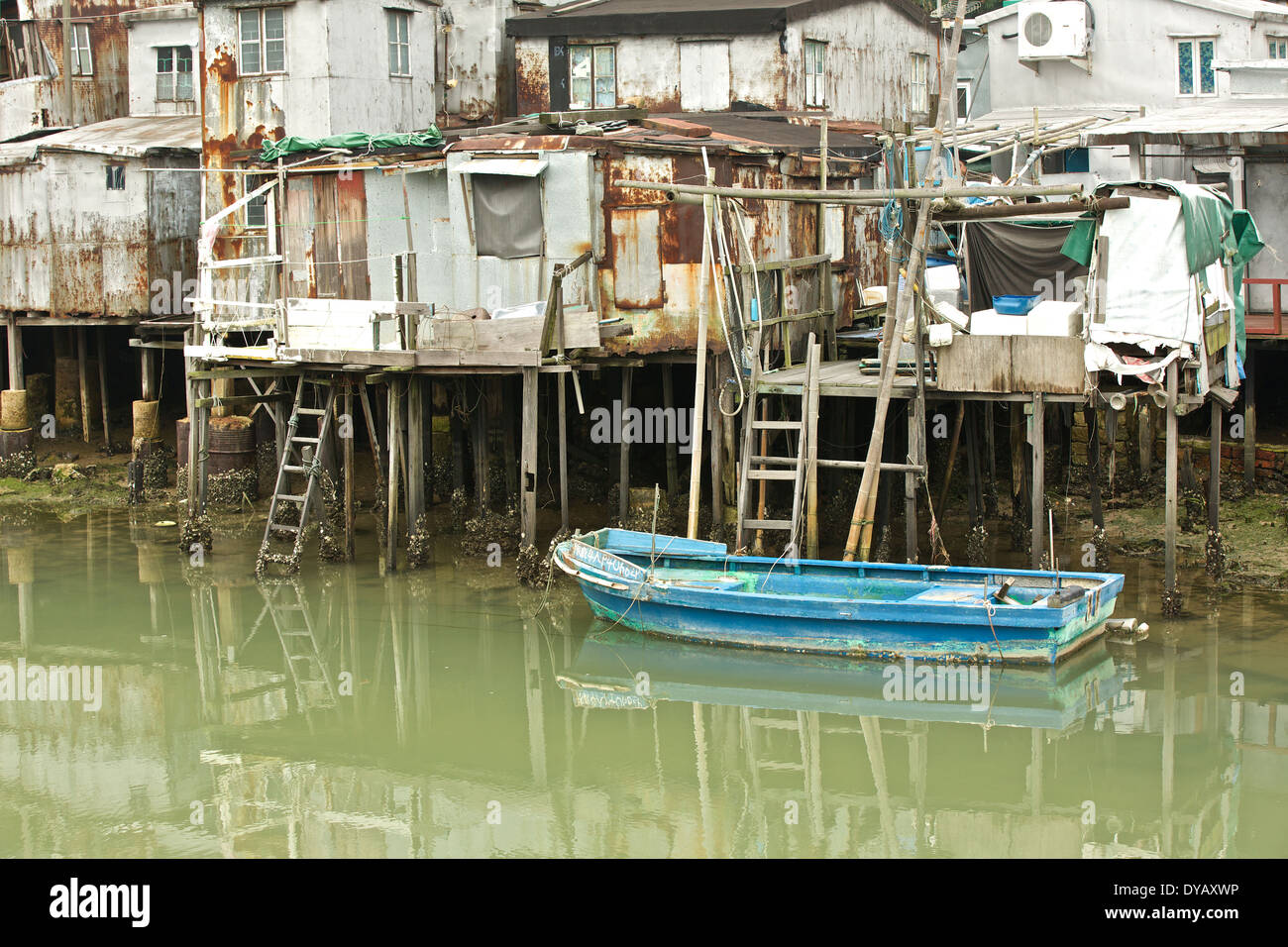 Petit bateau de pêche amarré cabanes de pêche sur pilotis contre dans 'Tai O' Chinois traditionnel village de pêcheurs sur l'île de Lantau, à Hong Kong. Banque D'Images