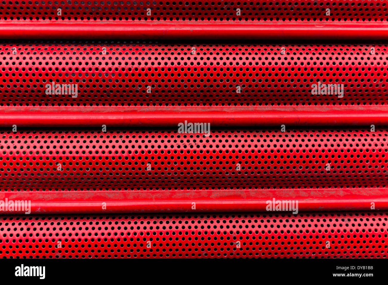 Close up of red metal volets protégeant façade boutique Banque D'Images