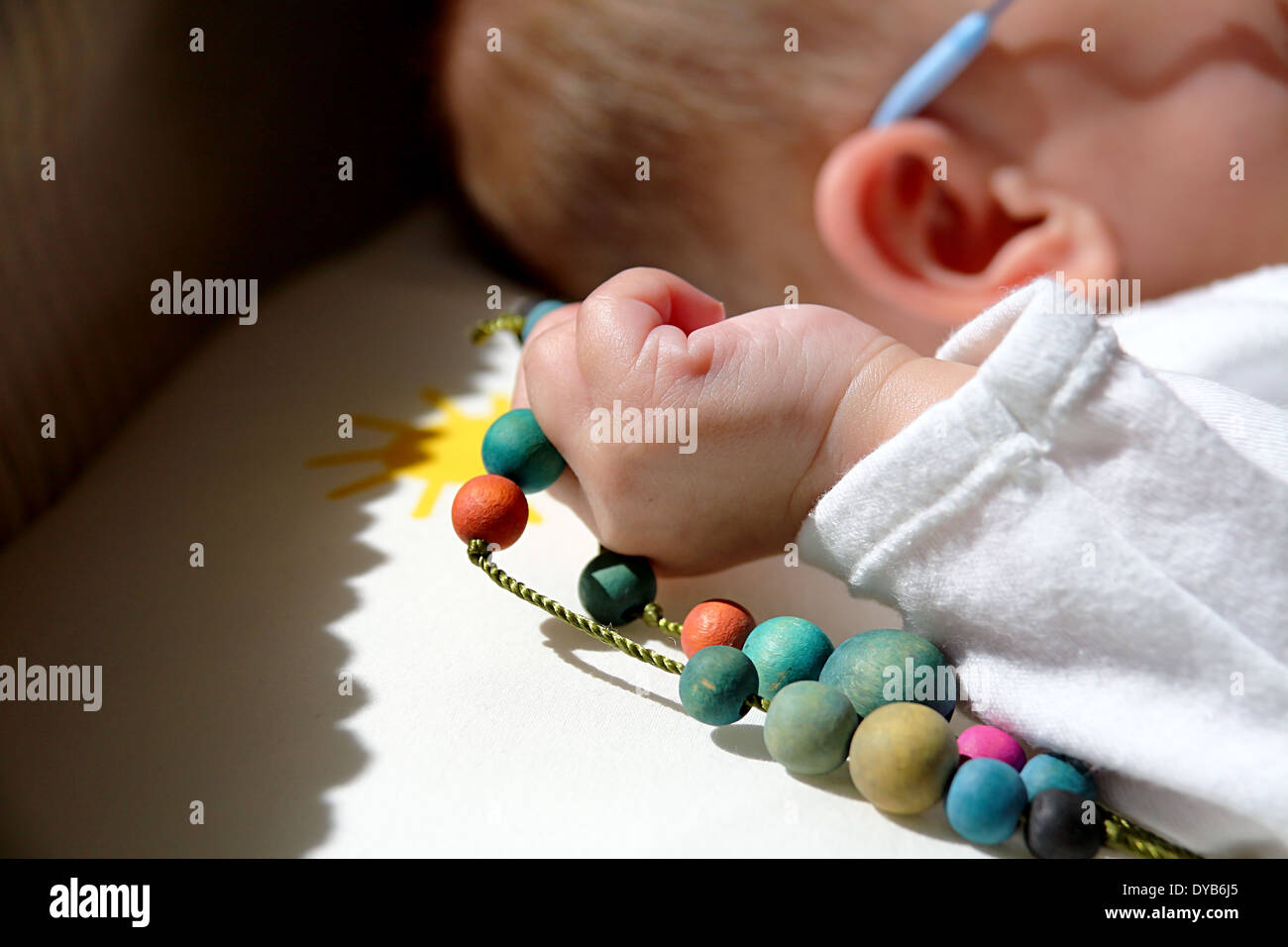 Collier de couleur dans une main de bébé Banque D'Images