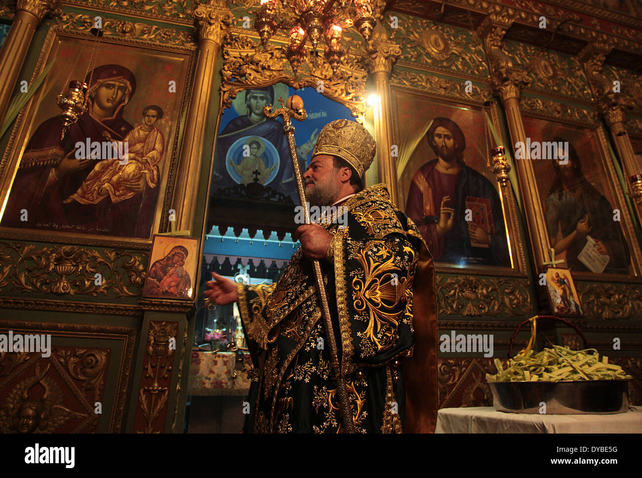 La bande de Gaza. 13 avr, 2014. Un prêtre orthodoxe à la tête d'un Dimanche des Rameaux la messe à l'église Saint Porfirios à Gaza le 13 avril 2014. Dimanche des Rameaux marque le retour triomphant de Jésus Christ à Jérusalem, quand une foule enthousiaste l'accueillit en agitant les feuilles de palmier, une semaine avant sa crucifixion. Eglises orientales orthodoxes célèbrent Pâques selon le calendrier julien. Credit : Yasser Qudih/Xinhua/Alamy Live News Banque D'Images