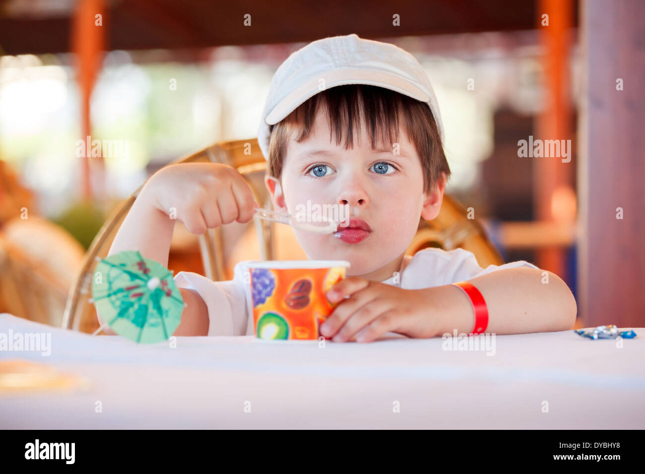 Cute little boy eating ice cream au café à l'intérieur Banque D'Images