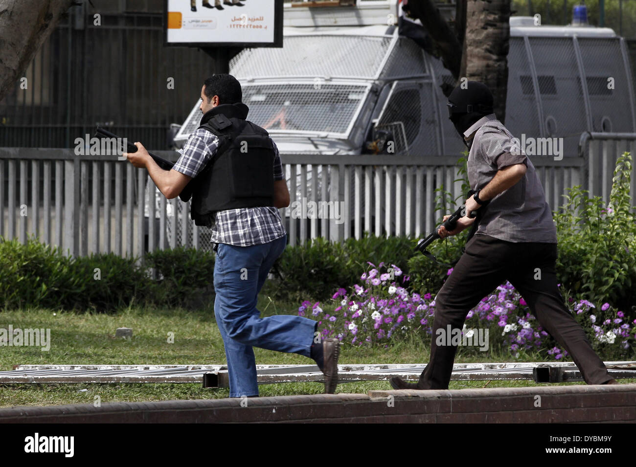 Le Caire, Égypte. 13 avr, 2014. Des policiers armés tentent de pénétrer dans la porte de l'Université Ain Shams au cours d'affrontements avec des étudiants qui sont des partisans des Frères musulmans et le président déchu Mohamed Morsi, après une protestation contre l'ancien chef de l'armée Abdel-Fattah al-Sisi a décidé de courir pour le président, au Caire, 13 avril 2014 © Mohammed Bendari APA/Images/ZUMAPRESS.com/Alamy Live News Banque D'Images