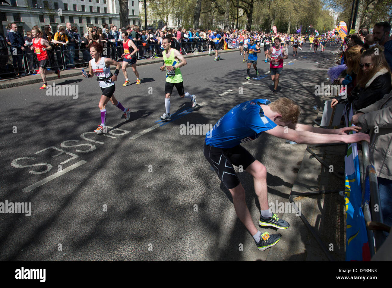 Londres, Royaume-Uni. 13 avr, 2014. Les concurrents s'exécutant dans la principale manifestation publique de la Vierge Argent Marathon de Londres 2014. Ces glissières de prendre part et de soulever d'énormes sommes d'argent pour les organisations de bienfaisance fo. Beaucoup de coureurs sur la suite de la course souffrent de crampes ou autres douleurs nécessitant l'étirement. Crédit : Michael Kemp/Alamy Live News Banque D'Images