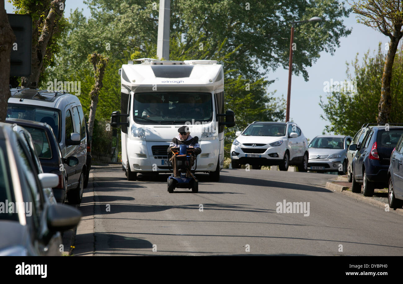 Vieil homme sur la mobilité non valide le trafic holding up scooter Banque D'Images