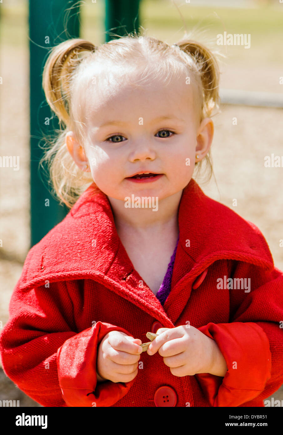Mignon, adorable petite fille de 16 mois à l'affiche sur un parc jeux pour enfants Banque D'Images