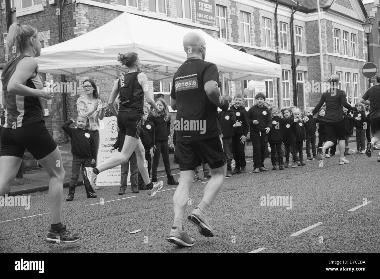 2014 Le Marathon de Manchester : coureurs passant membres du choeur d'enfants d'Altrincham qui encouragez-les Banque D'Images