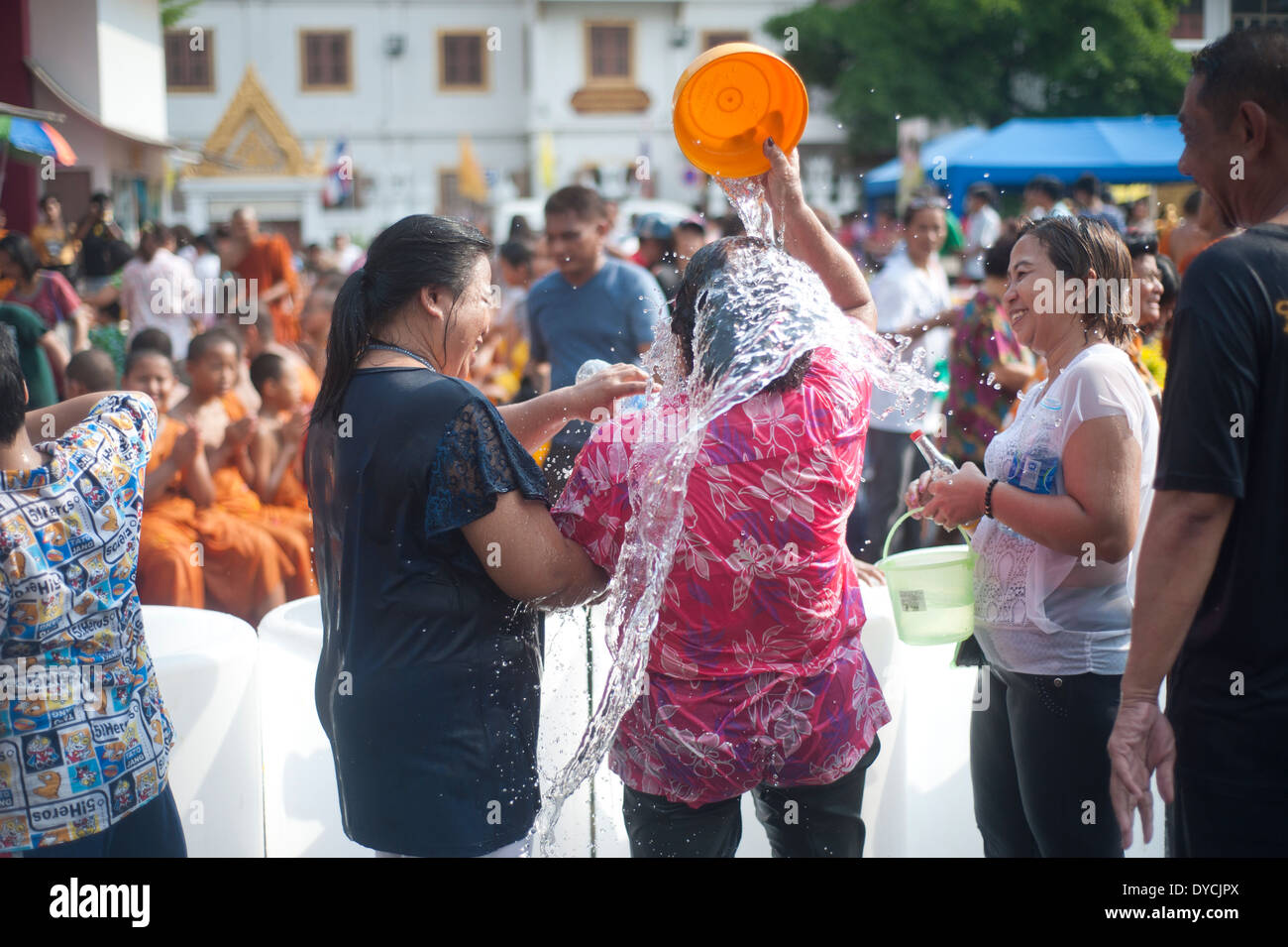 Bangkok, Thaïlande - Moines célébrer Songkran festival, nouvel an thaï, femme verse de l'eau sur elle Banque D'Images