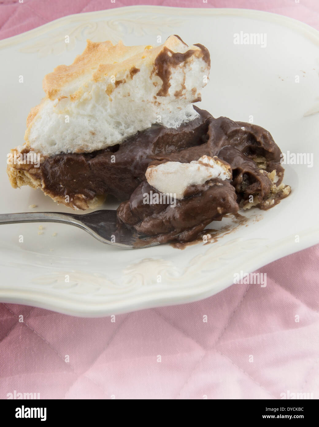 Une tranche de tarte au chocolat fait maison sur une plaque blanche avec une fourchette. Banque D'Images