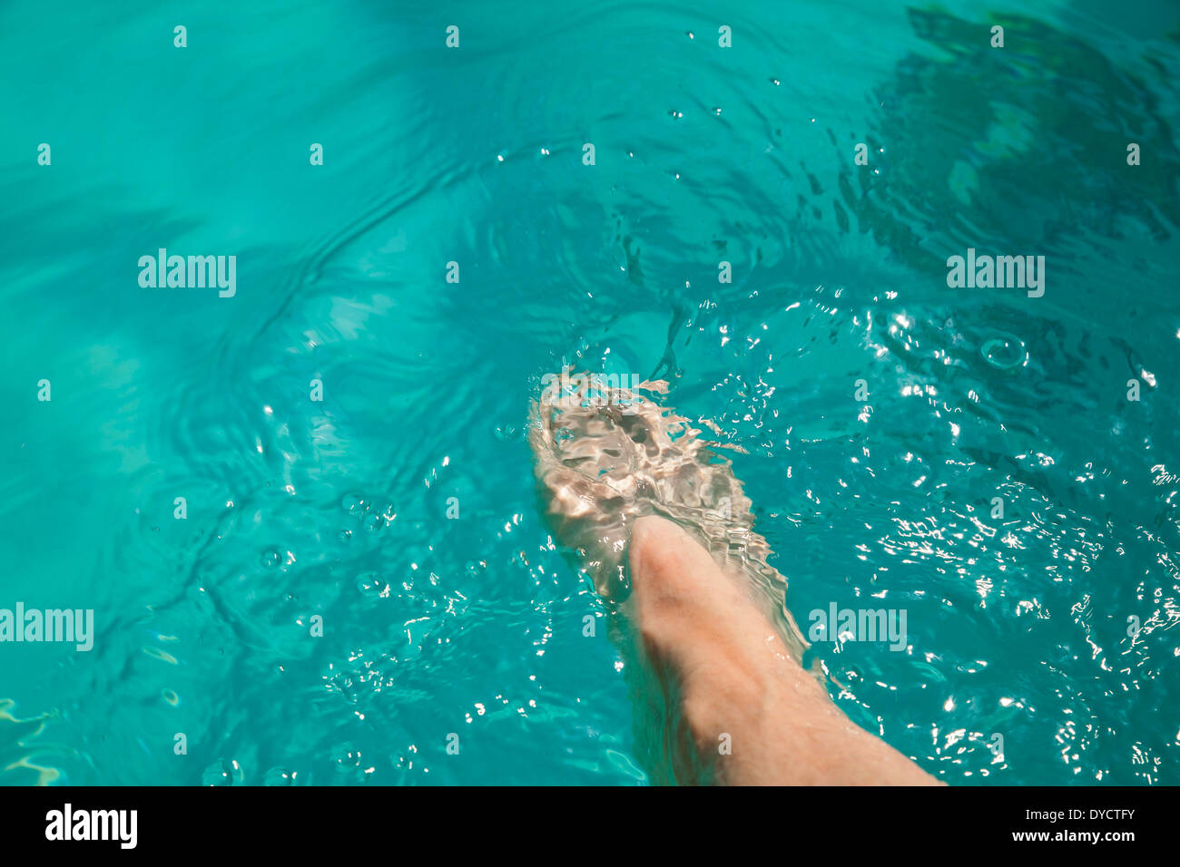 Une femme caucasienne dips son pied dans une piscine de l'hôtel. Banque D'Images