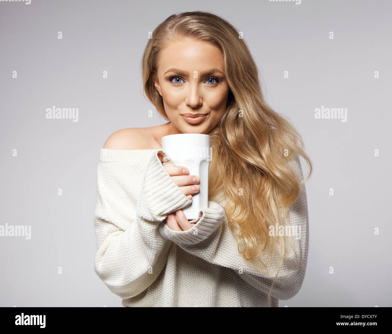Portrait of young woman wearing sweater de boire du café. Beau portrait modèle féminin avec une tasse de café chaud. Banque D'Images