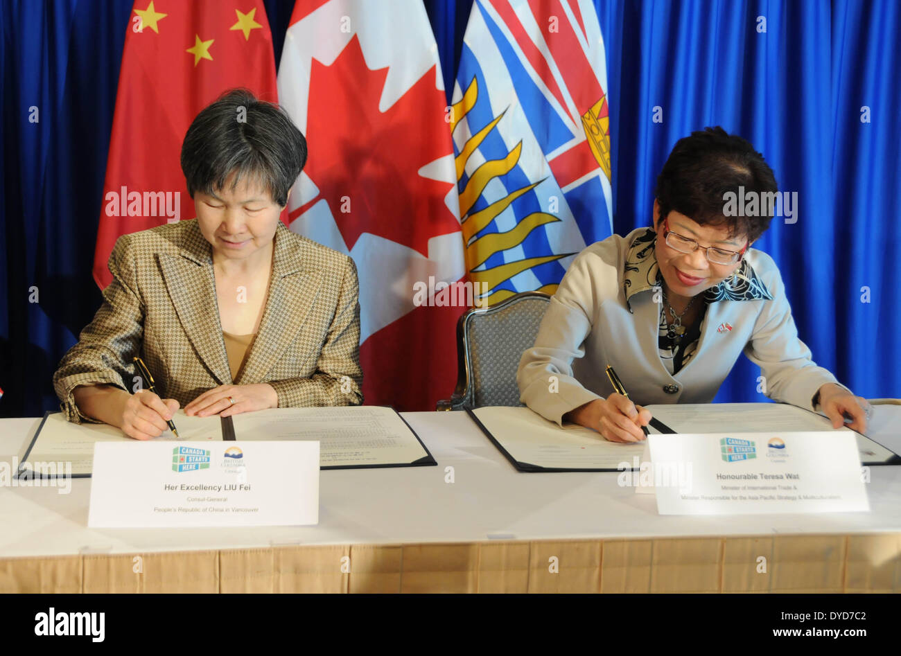 Vancouver, Canada. 14 avr, 2014. Liu Fei (L), consul général chinois à Vancouver, et Teresa Wat, ministre du Commerce international, de signer un accord pour stimuler les échanges commerciaux et les investissements, à Vancouver, Canada, le 14 avril 2014. © Jiang Yaping/Xinhua/Alamy Live News Banque D'Images