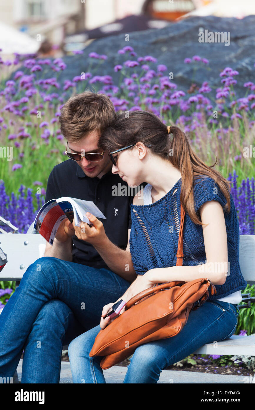 Un couple de jeunes touristes regarder le guide Lonely Planet book à Prague. Banque D'Images