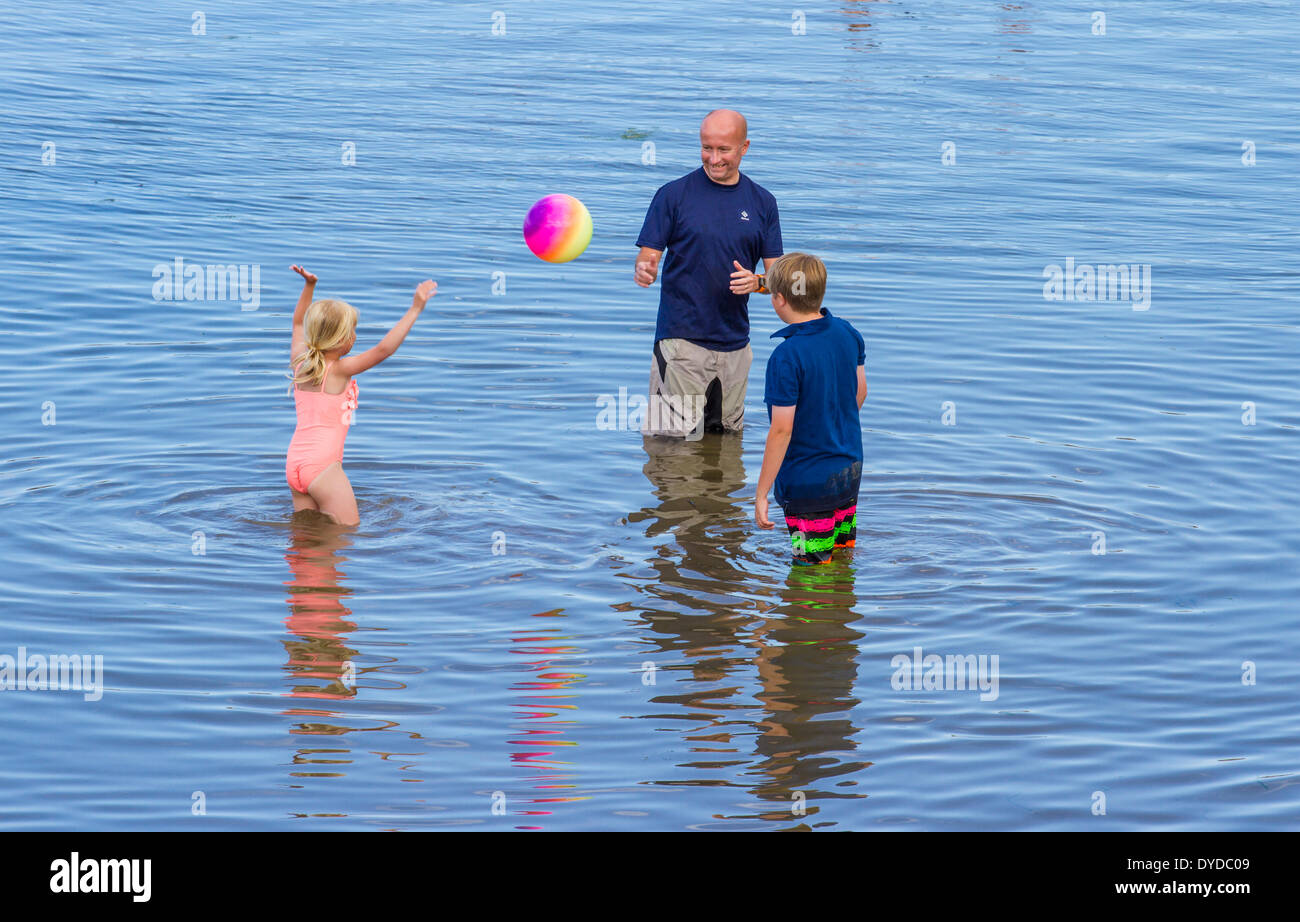 Une famille de jouer un match dans la mer. Banque D'Images
