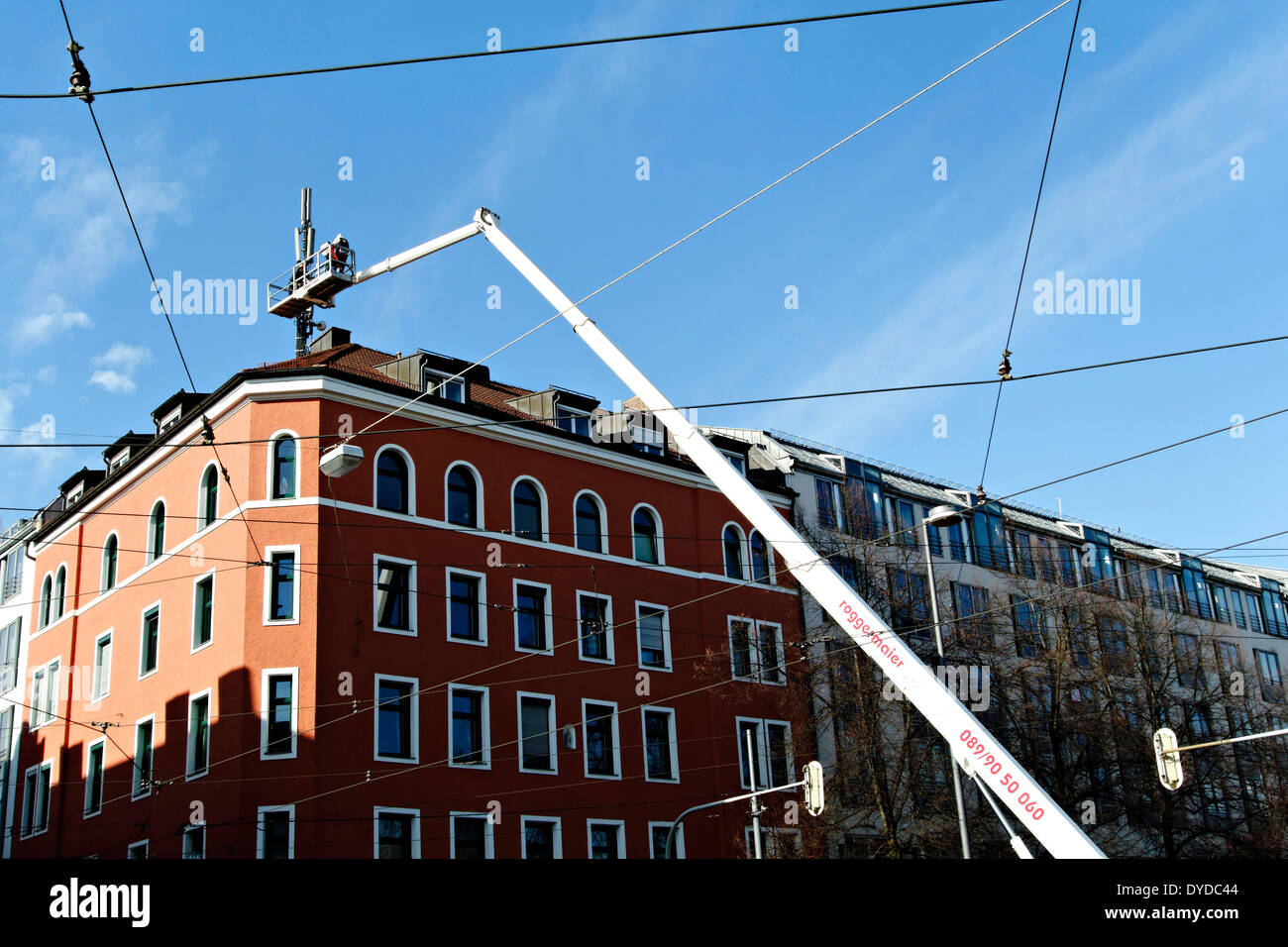 Le maintien d'un mât de télécommunication des ouvriers sur le toit, Munich, Haute-Bavière, Allemagne, Europe Banque D'Images