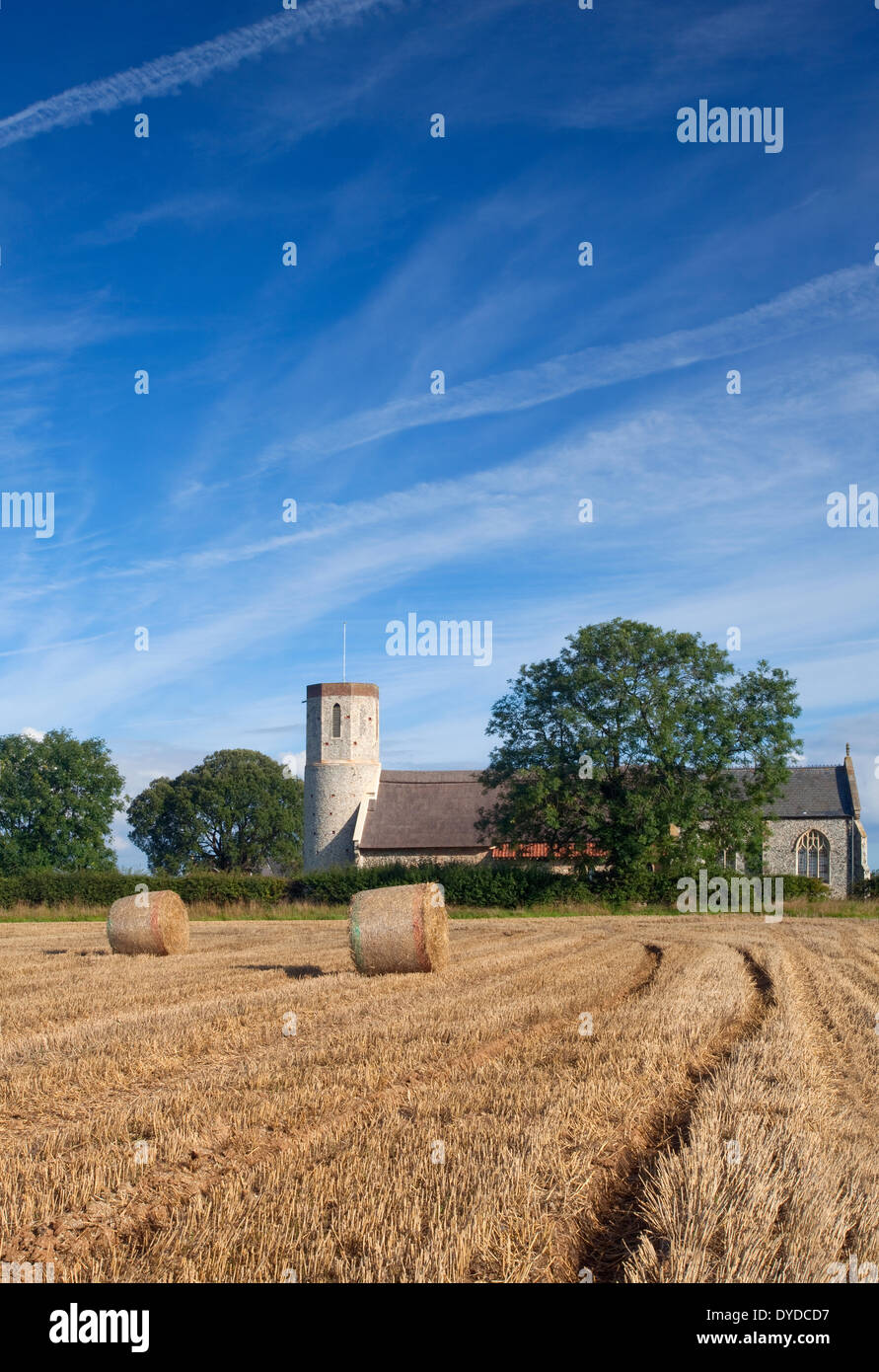 Someton ouest église et un champ de bottes de foin dans le Norfolk. Banque D'Images