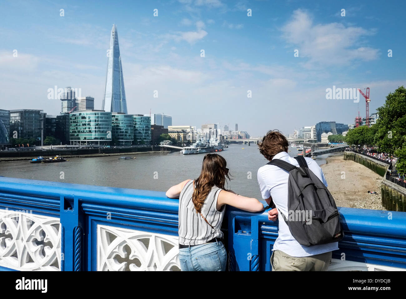 Un couple debout sur le Tower Bridge à la recherche à la Tamise. Banque D'Images