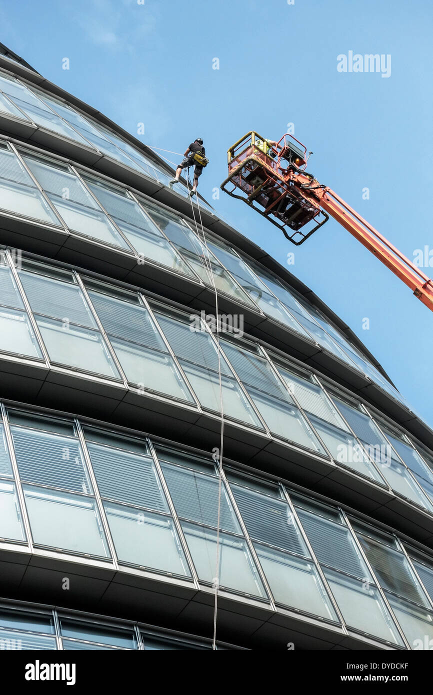 Les travailleurs ayant un très bon sujet au vertige effectuer des opérations d'entretien sur les fenêtres de l'Hôtel de ville de Londres. Banque D'Images