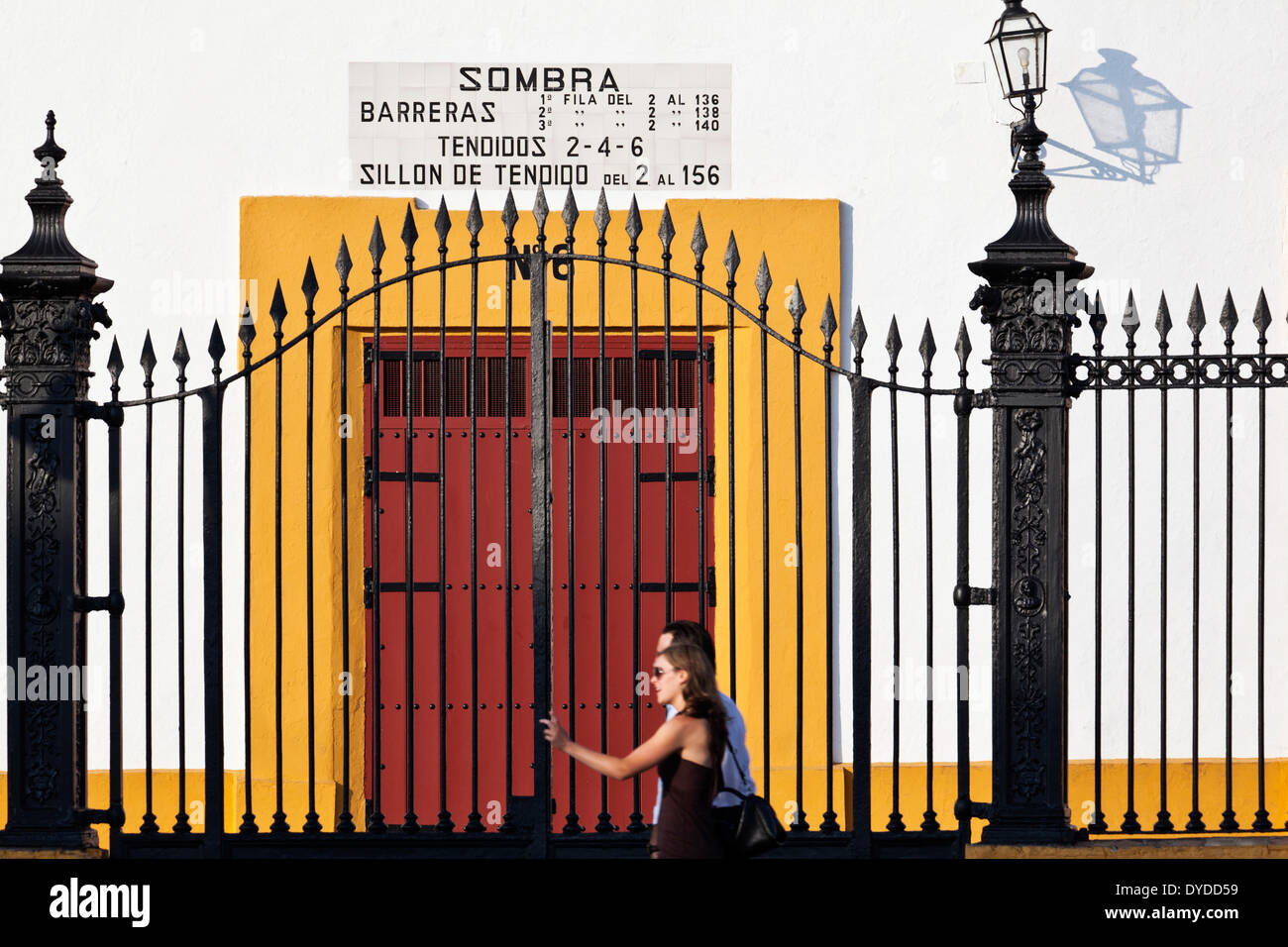 Les touristes à pied par la porte d'entrée de la Plaza de toros de la Real Maestranza de Séville. Banque D'Images