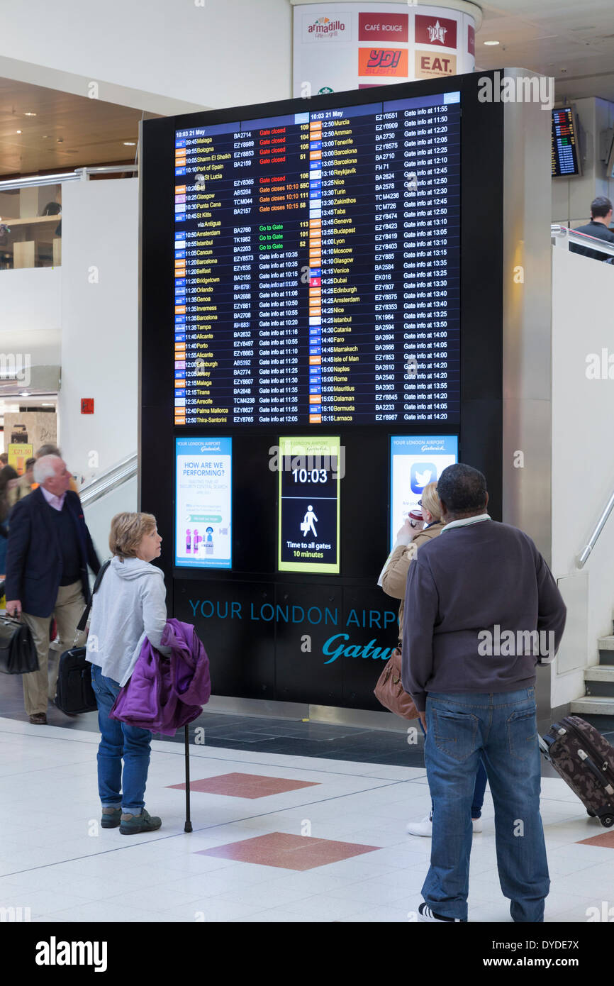 Les passagers qui s'enregistrent un départ à l'aéroport de Gatwick. Banque D'Images