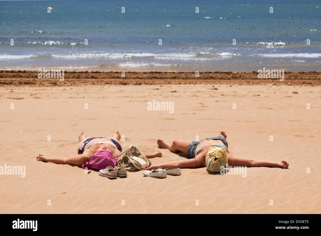 Deux femmes avec des chefs la propagation d'aigle sur la plage au soleil. Banque D'Images
