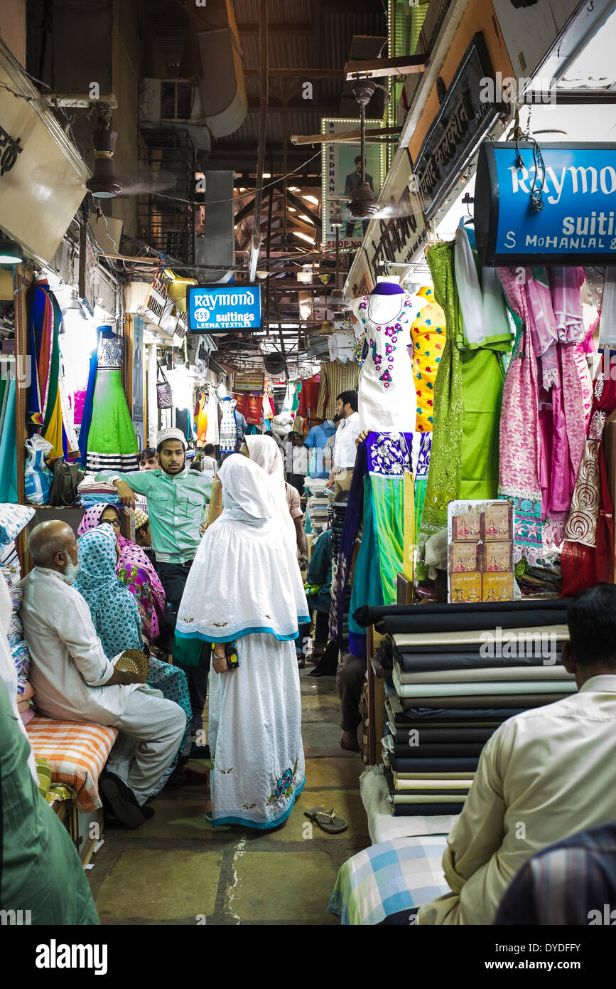 Un Bohri famille musulmane en costumes traditionnels s'arrêter pour une discussion à l'aide d'un chiffon marché de gros. Banque D'Images